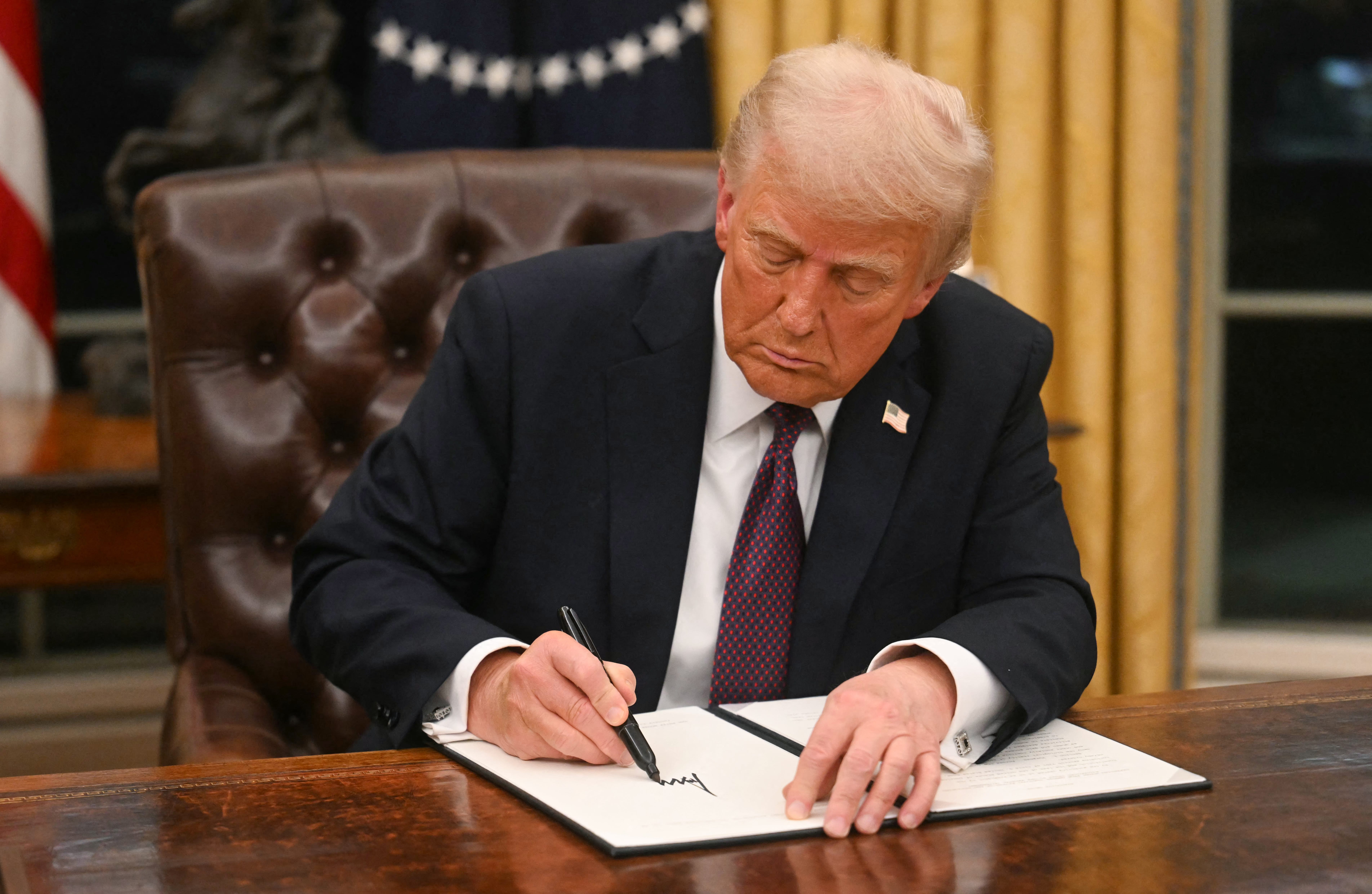 President Donald Trump signs an executive order in the Oval Office of the White House in Washington, DC, on Jan. 20, 2025.