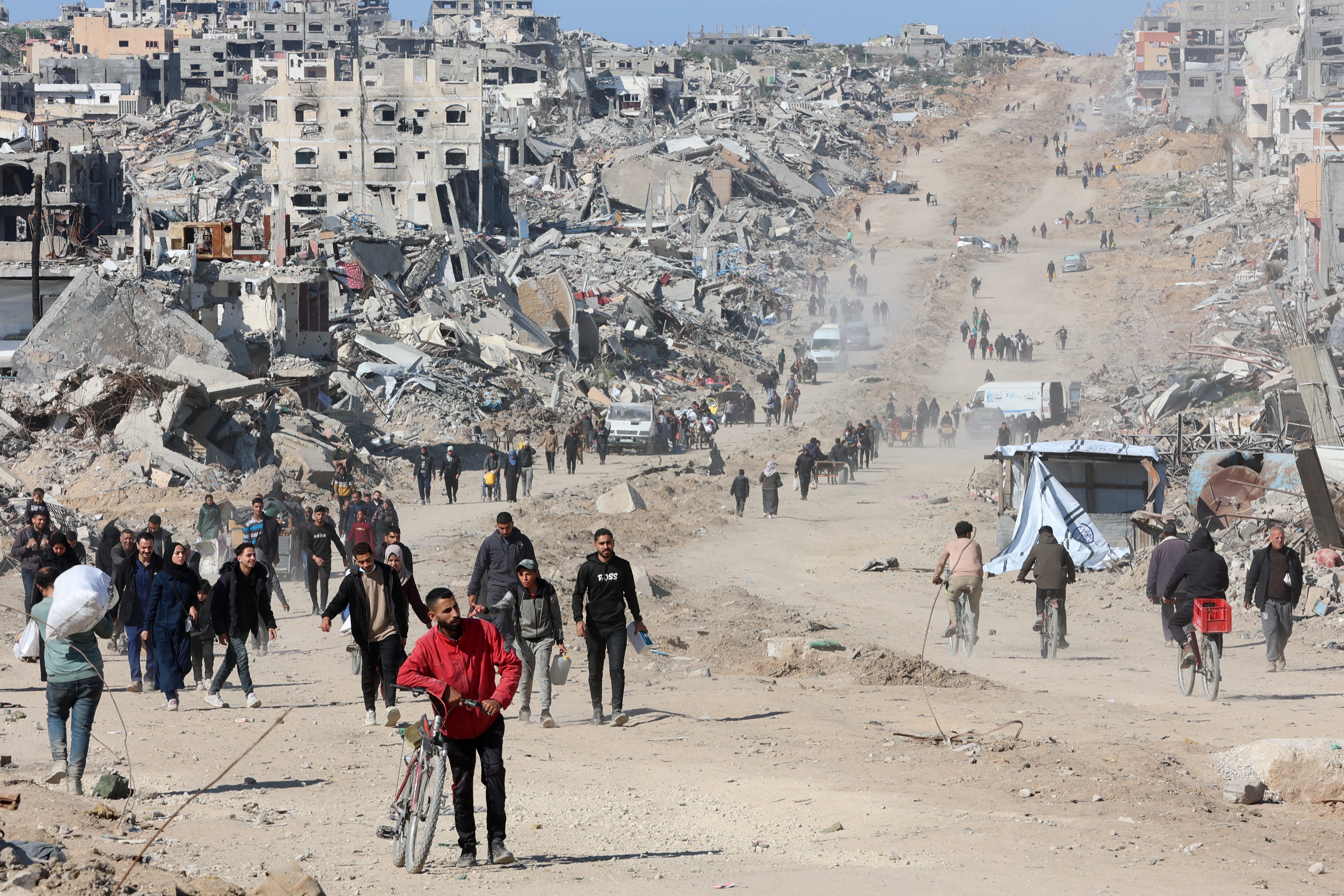 Displaced Palestinians walk along the rubble of destroyed buildings in Gaza on Jan. 21, 2025.