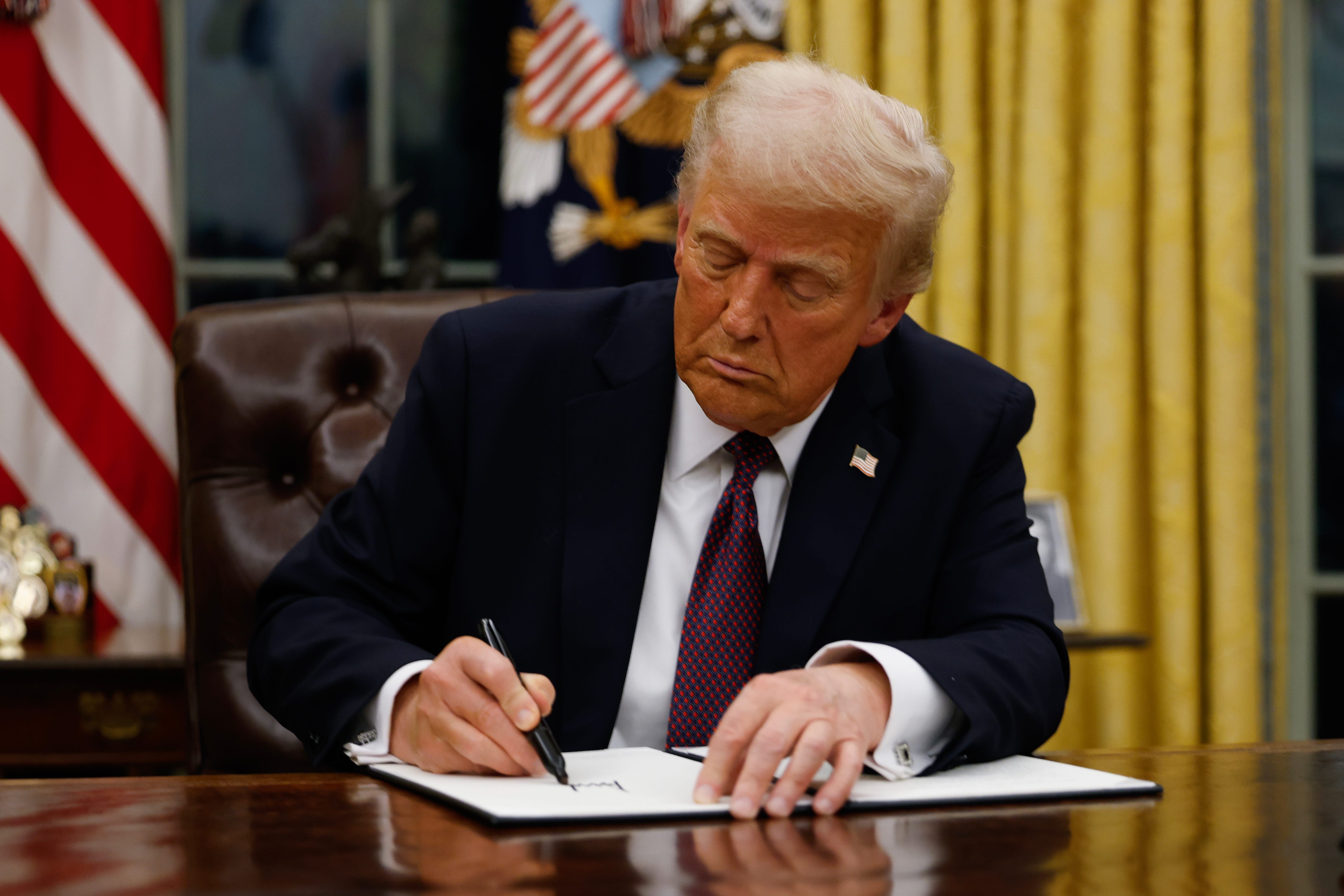 President Donald Trump signs executive orders in the Oval Office of the White House on January 20, 2025 in Washington, DC.