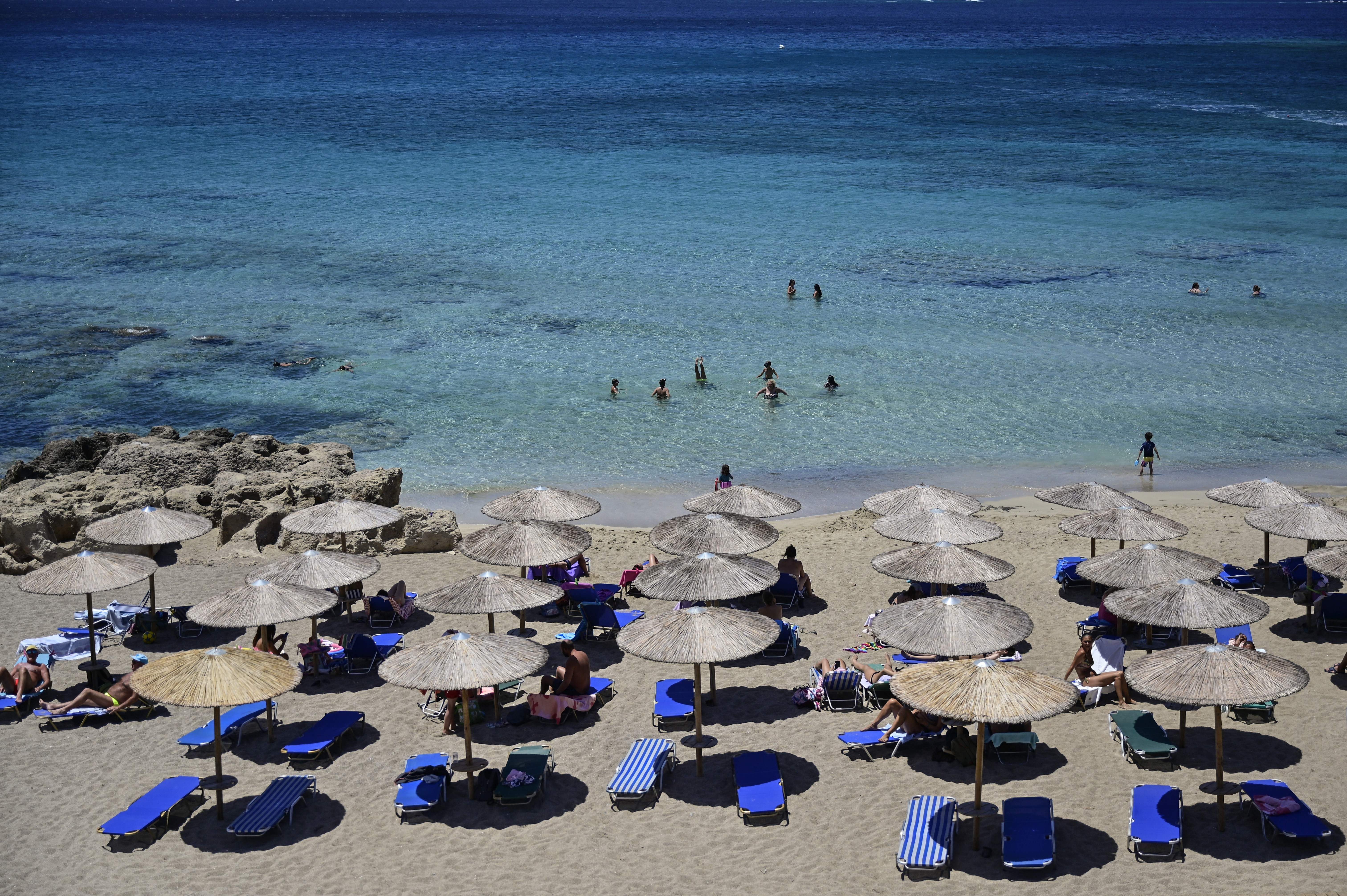 Tourists enjoy the beach in Phalasarna, northwest of the Greek mediterranean island of Crete.