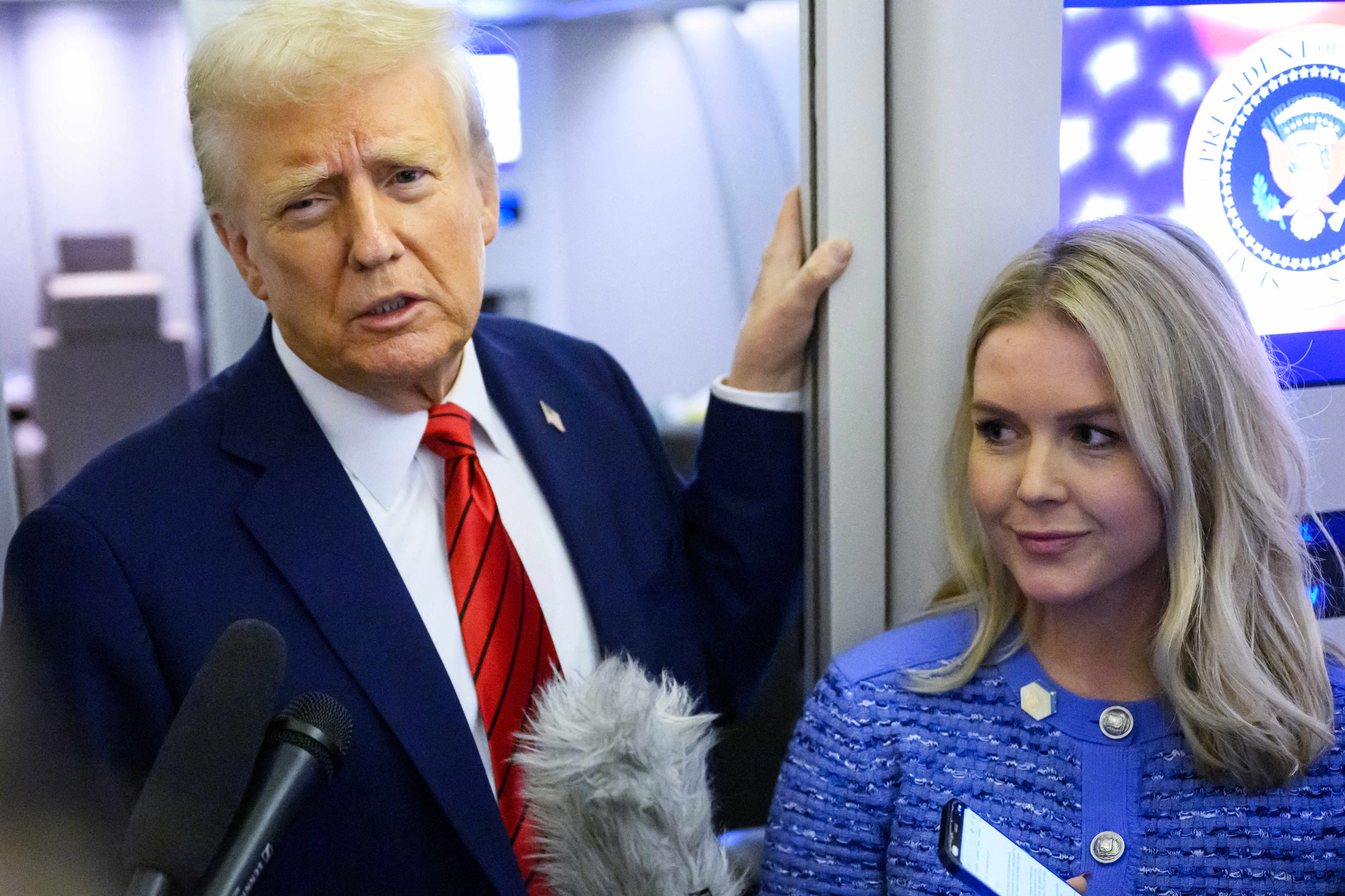 President Donald Trump, with White House press secretary Karoline Leavitt, speaks to reporters on Air Force One on Jan. 27, 2025.