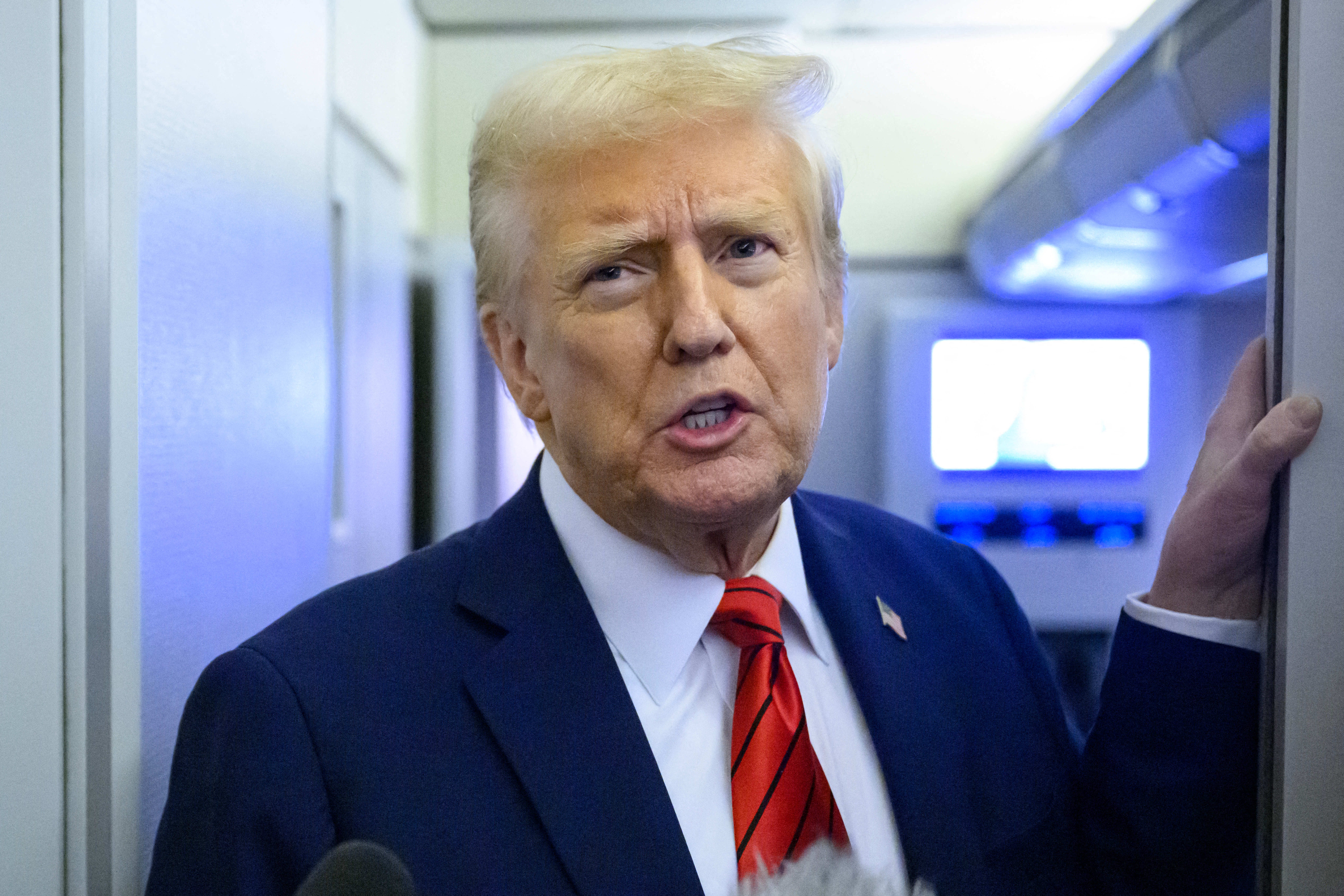 President Donald Trump speaks to reporters while in flight on Air Force One en route Joint Base Andrews in Maryland on January 27, 2025.