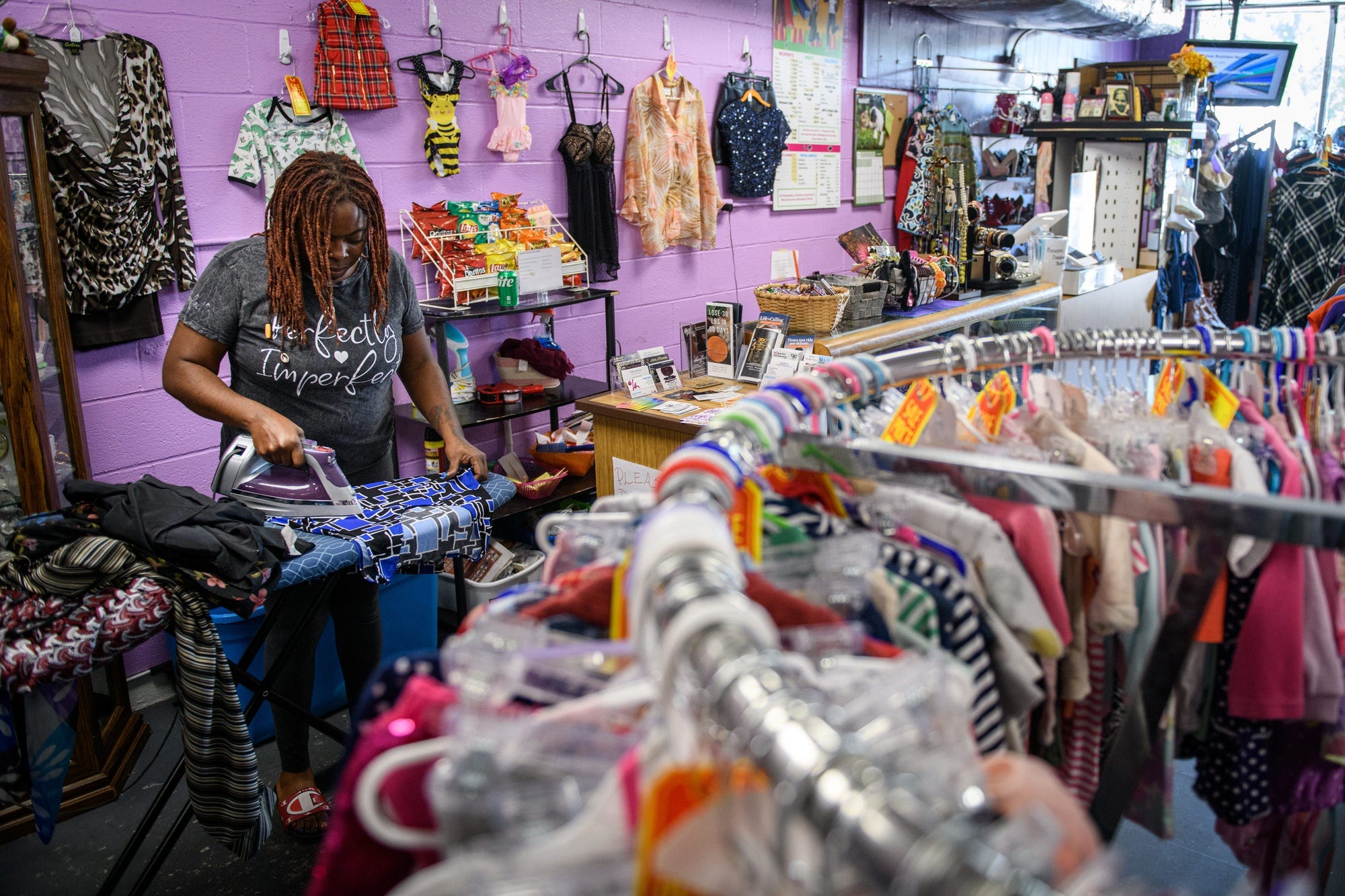 Taleshia Douglas irons some clothing before putting it out on the racks at Shopaholix Consignment and Thrift Store in Fayetteville, N.C. Eighty-five percent of respondents in a new survey said they believe thrifting benefits the environment.