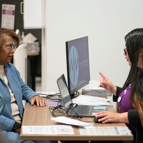 Katelyn Hill-Fuqua, 64 of Romulus, left, speaks to Carla Hart, 33, of Dearborn Heights, a tax preparer and Wayne Metropolitan Community Action Agency site coordinator in Detroit on Wednesday, Jan. 29, 2025.