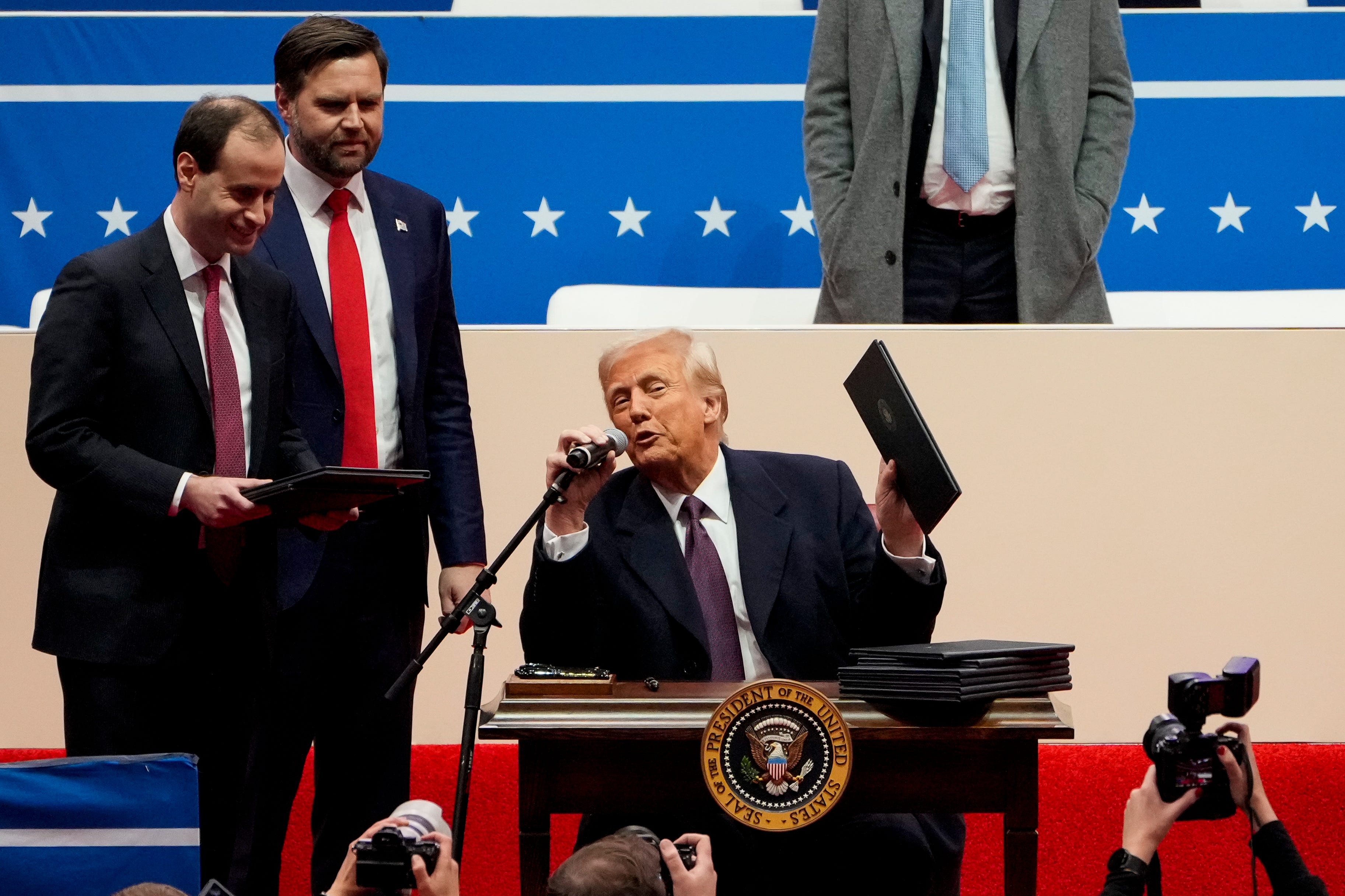 President Donald Trump comments on a stack of executive orders he signs during the inauguration parade for President Donald Trump at Capital One Arena in Washington D.C., on Monday, Jan. 20, 2025.