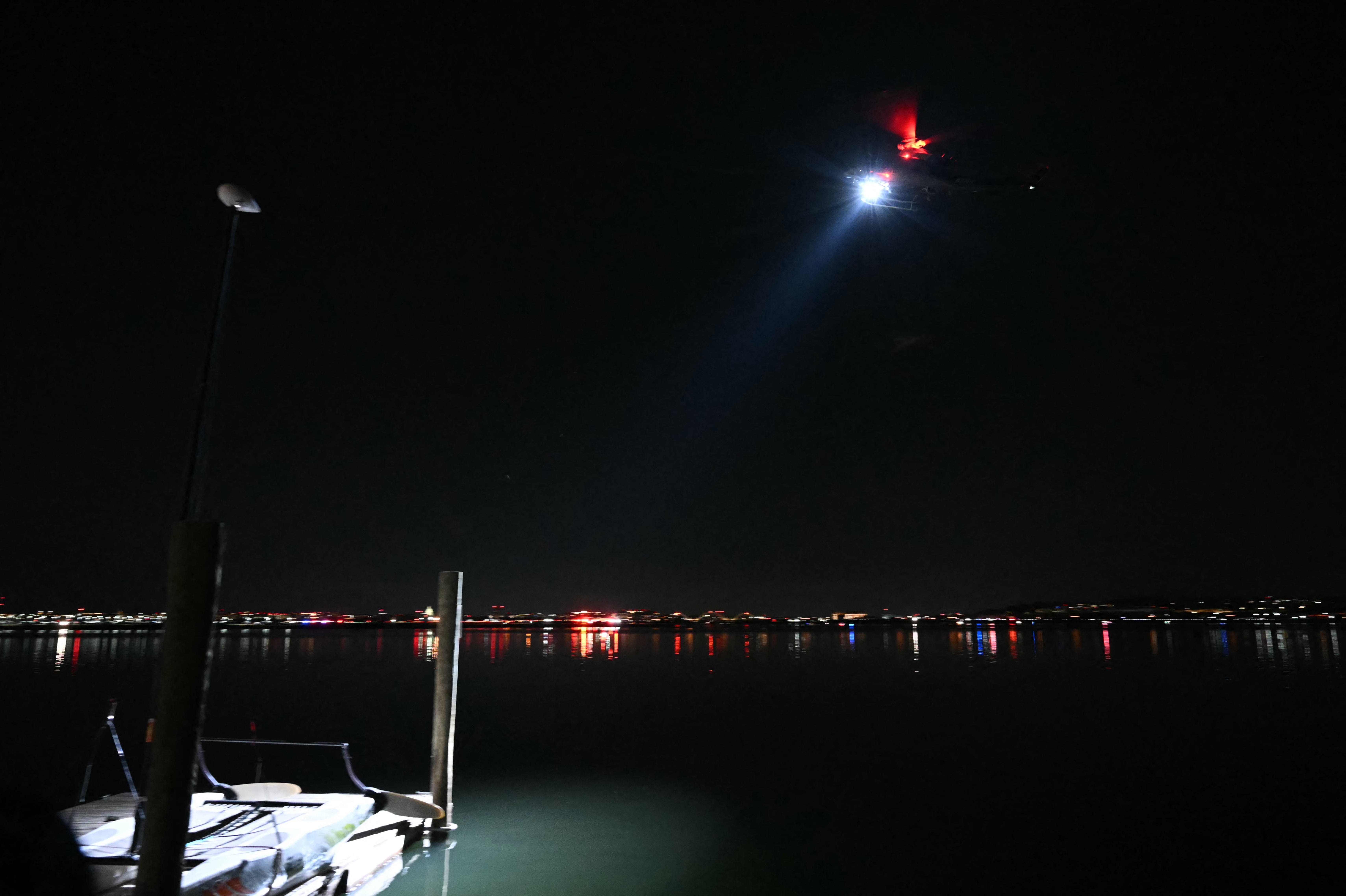 A search and rescue helicopter searches the water of the Potomac River after a plane on approach to Reagan National Airport crashed into the river, seen from Alexandria, Virginia, on Jan. 29, 2025. A regional jet from Kansas crashed into Washington's Potomac River after colliding mid-air with a military helicopter near Reagan National Airport, officials said Jan. 29, prompting a major emergency response and grounding all flights.
