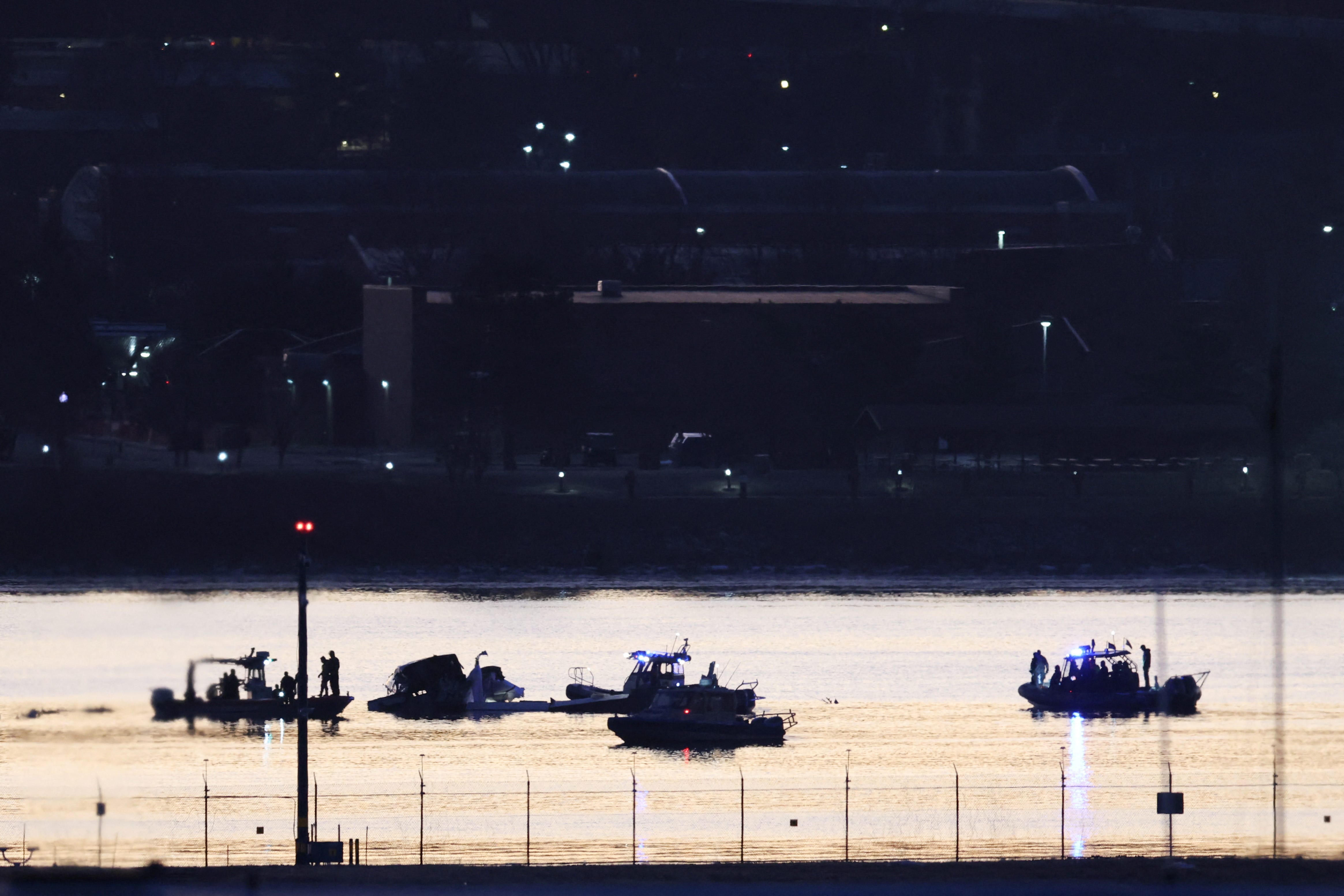 Rescuers on boats work at the site of the crash after a Black Hawk helicopter collided with the American Eagle flight 5342, which was approaching Reagan Washington National Airport, and crashed into the Potomac River, outside Washington, D.C, January 30, 2025.