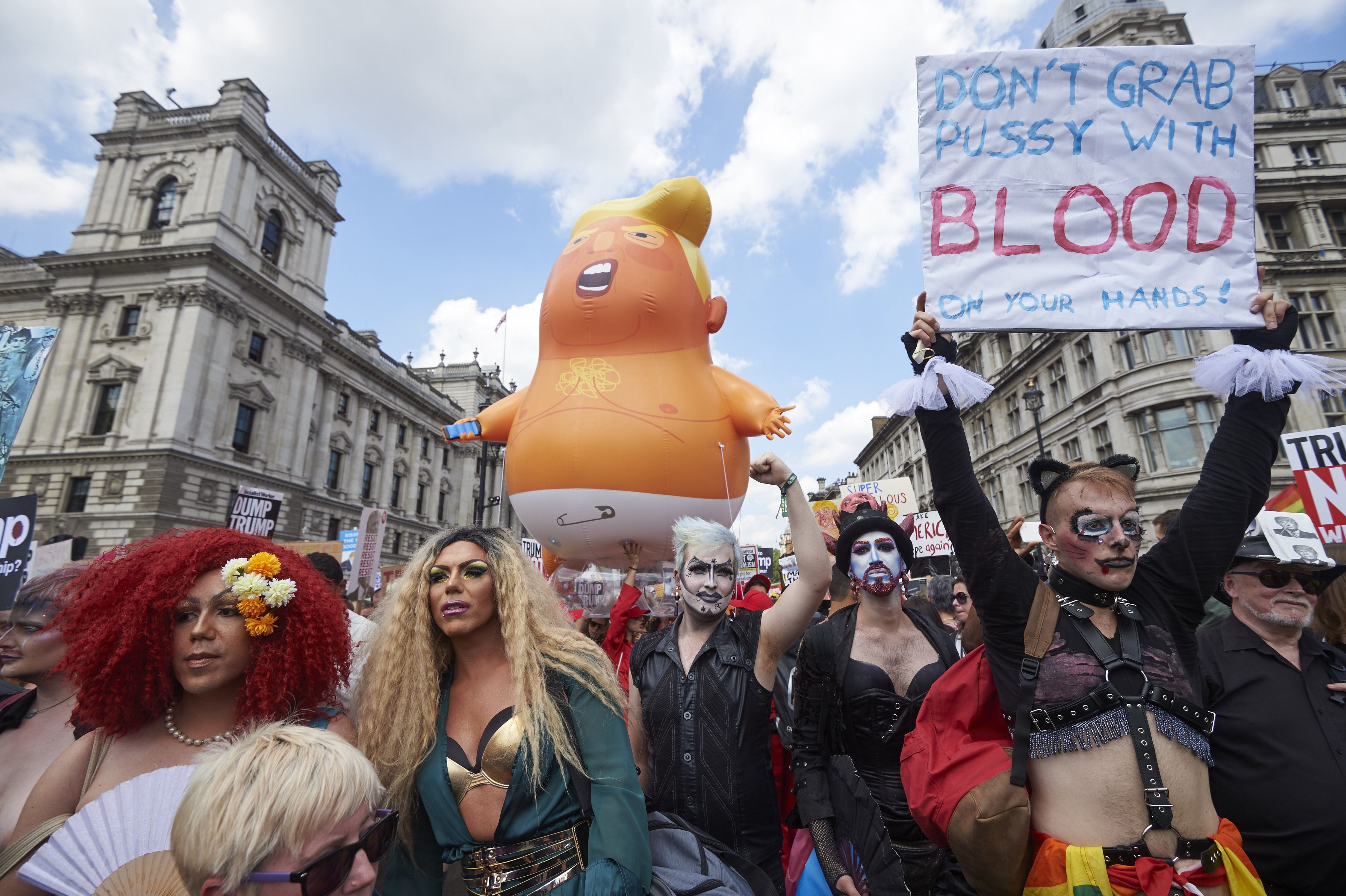 A giant balloon depicting US President Donald Trump as an orange baby joins drag queens and protesters against the UK visit of US President Donald Trump as they take part in a march and rally in London on July 13, 2018. - Tens of thousands of protesters demonstrated in London on Friday against US President Donald Trump, whose four-day visit to Britain has been marred by his extraordinary attack on Prime Minister Theresa May's Brexit strategy.