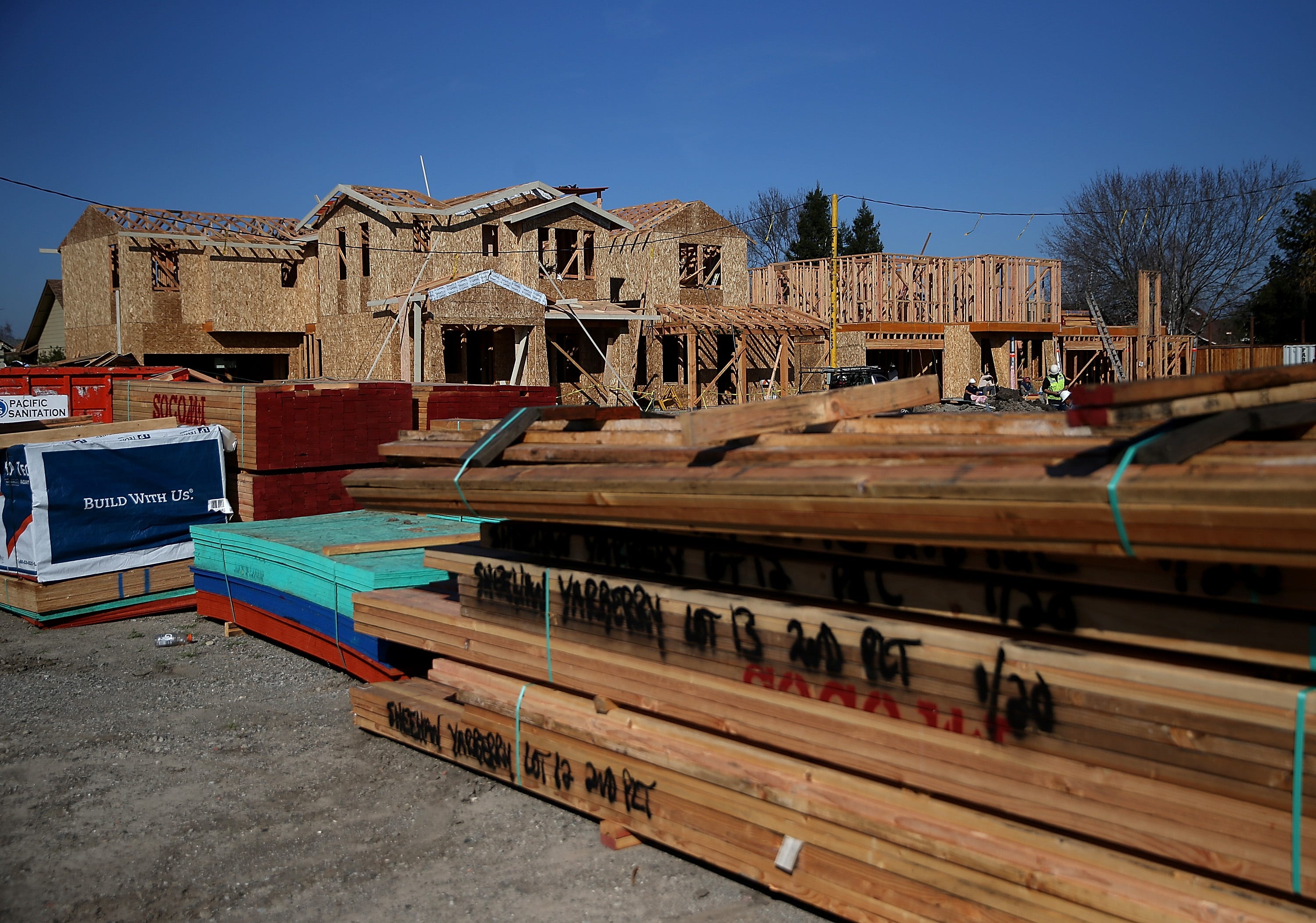 Stacks of lumber sit in front of homes under construction at a new housing development on Jan. 21, 2015, in Petaluma, Calif. According to a Commerce Department report, construction of new homes increased 4.4 percent in December, pushing the building of new homes to the highest level in nine years.