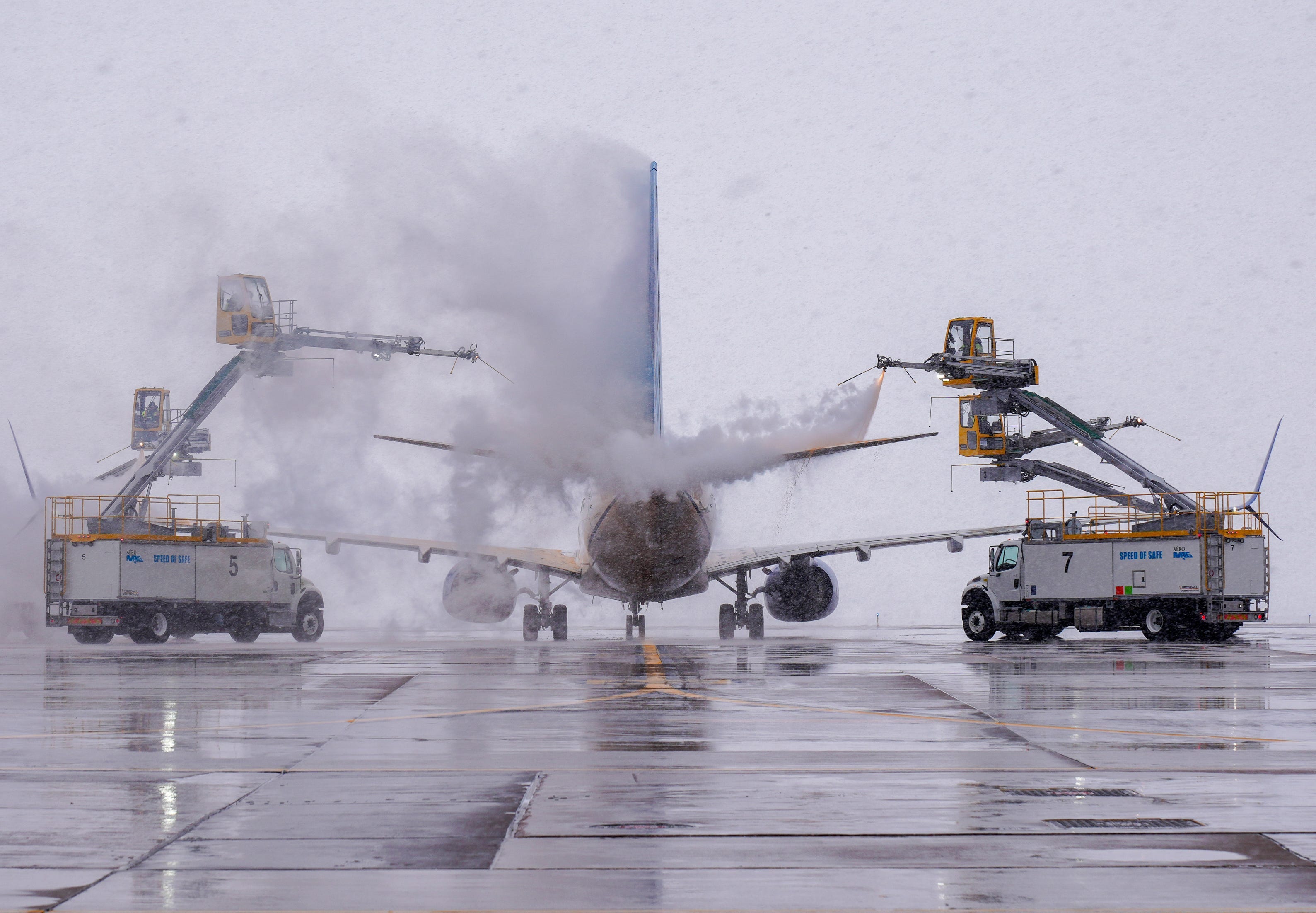 November 27, 2024: Workers spray deicing fluid on an airplane at Denver International Airport on Wednesday during a snowstorm.