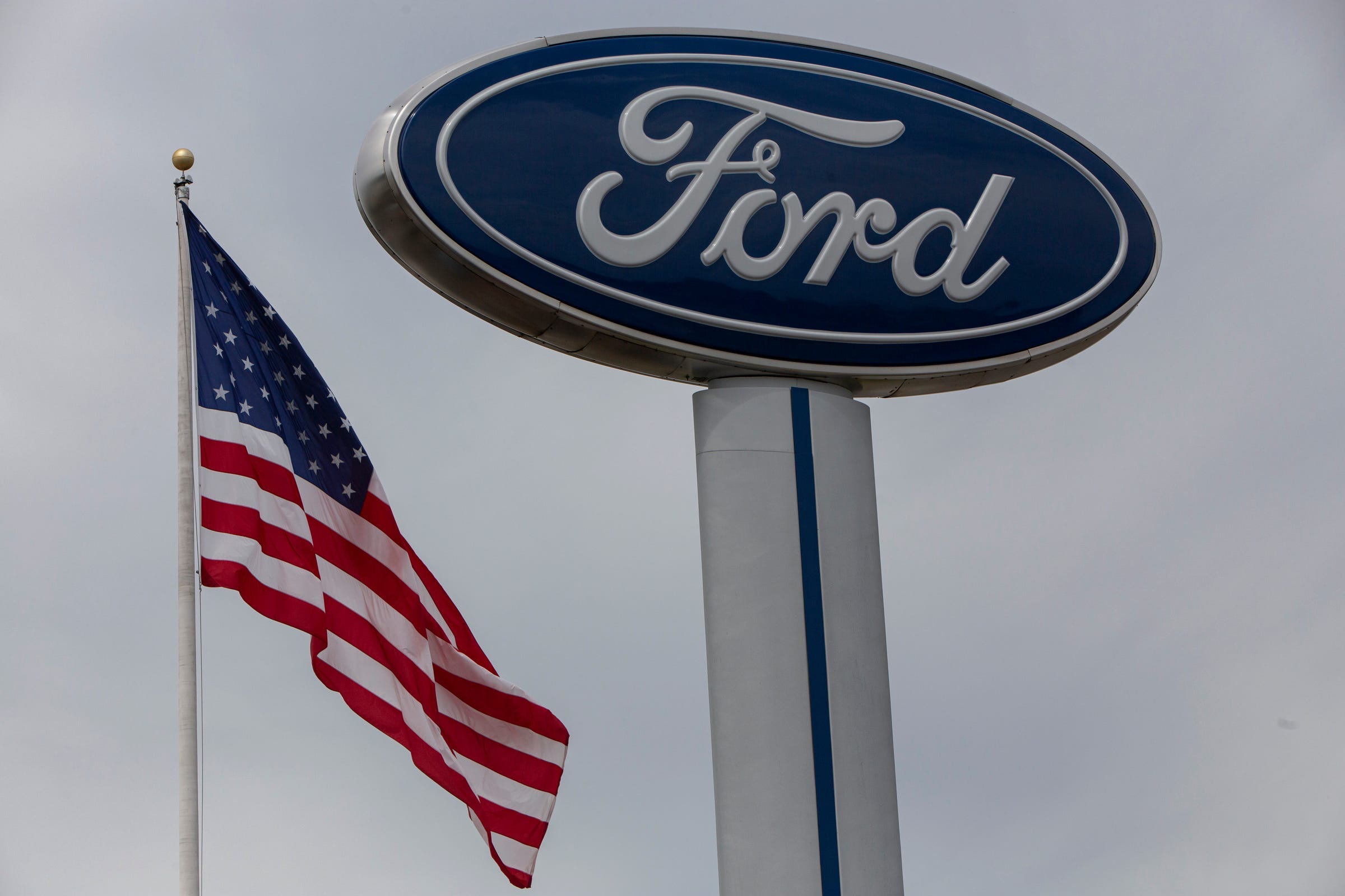 The American flag flaps in the wind at Village Ford in Dearborn on Wednesday, May 27, 2020.