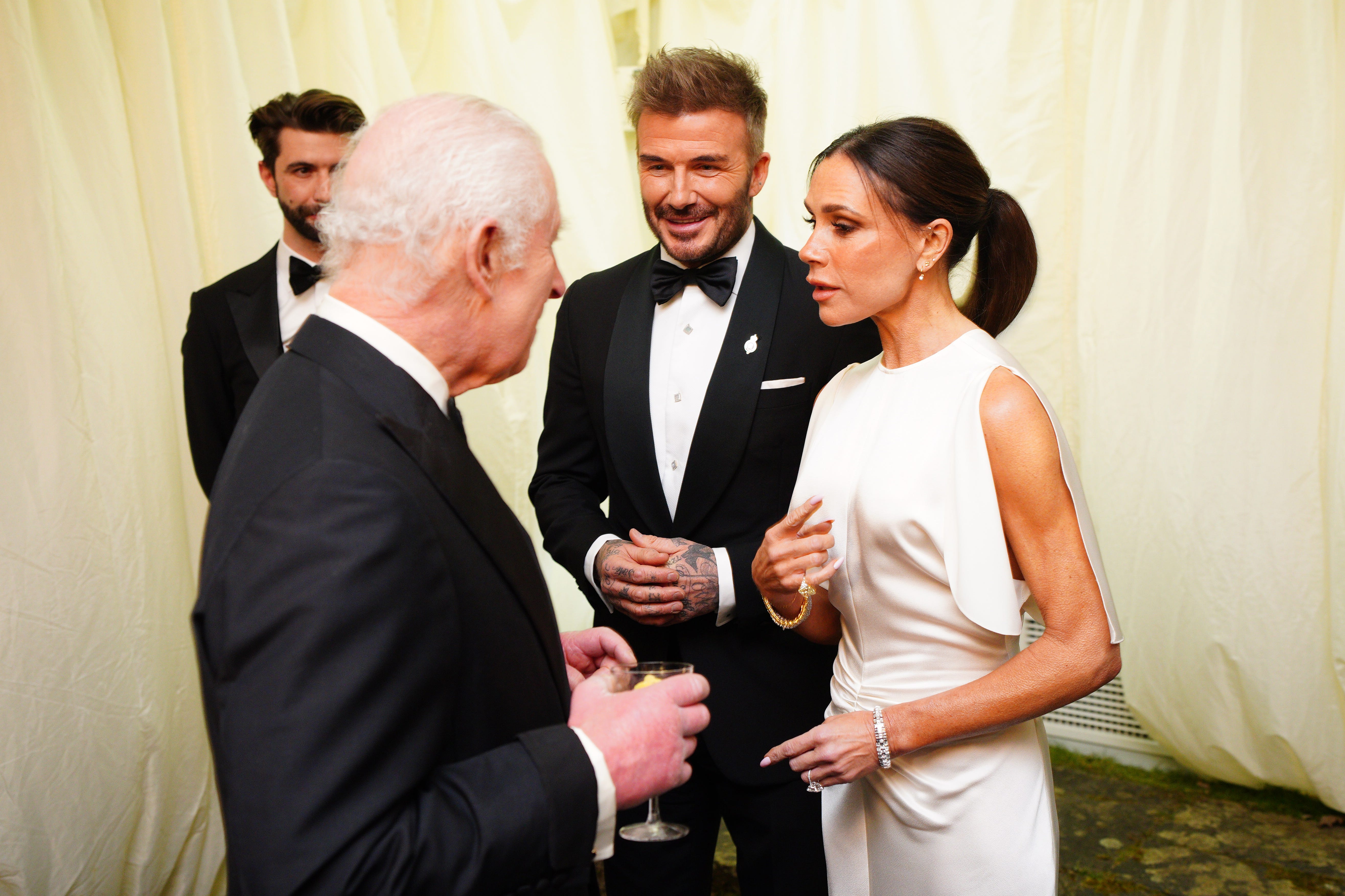King Charles III speaks to David Beckham and Victoria Beckham during a dinner in celebration of slow food at King Charles III's Gloucestershire estate, Highgrove Gardens on Feb. 7, 2025, in Tetbury, England.