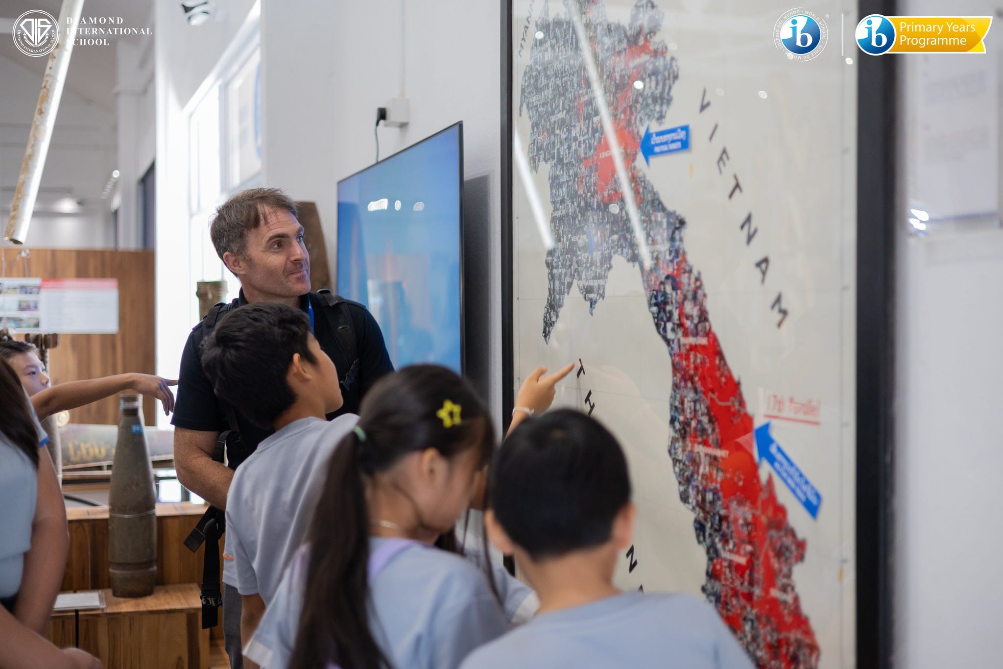Stephen White, academic coordinator at Diamond International School in Vientiane, Laos, takes fifth graders on Nov. 20, 2024, to the COPE Center to learn about how the United States dropped more than 2 million tons of bombs on Laos from 1964 to 1973. On the map, areas marked in red indicate bombed areas.