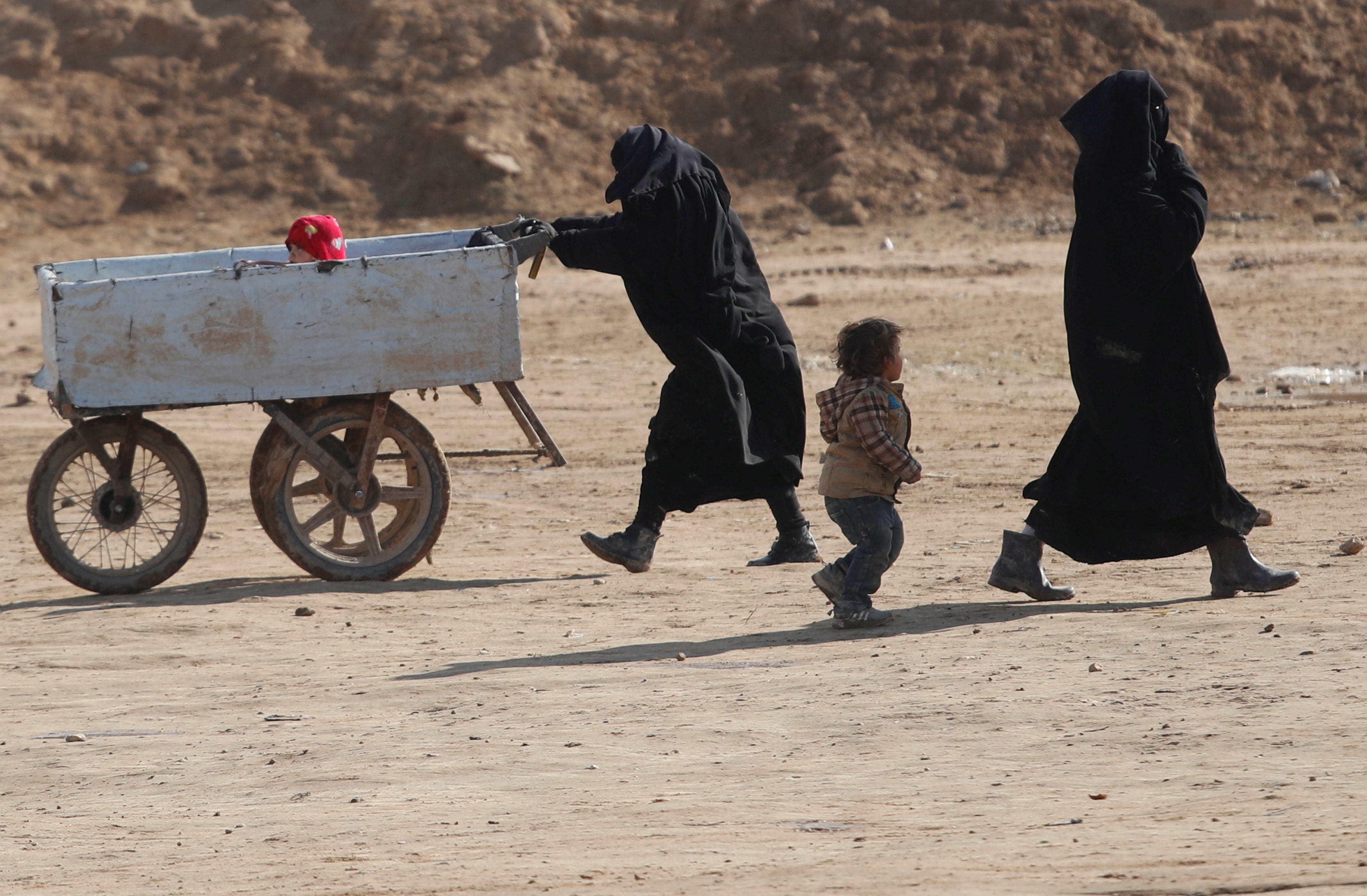 Women and children walk through al-Hol camp in Syria, on Jan. 8, 2020.