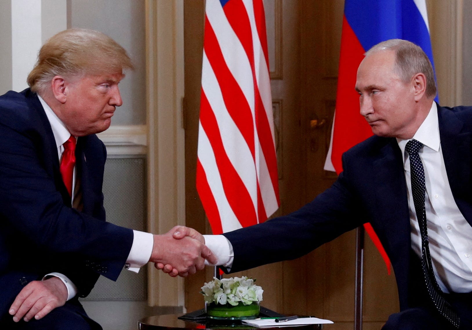 FILE PHOTO: U.S. President Donald Trump and Russian President Vladimir Putin shake hands as they meet in Helsinki, Finland, July 16, 2018. REUTERS/Kevin Lamarque/File Photo