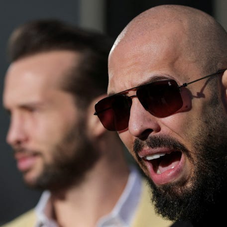 FILE PHOTO: Andrew Tate, next to his brother Tristan Tate, talks to media representatives after exiting the Bucharest courthouse, in Bucharest, Romania, January 9, 2025. Inquam Photos/Octav Ganea via REUTERS ATTENTION EDITORS - THIS IMAGE WAS PROVIDED BY A THIRD PARTY. ROMANIA OUT. NO COMMERCIAL OR EDITORIAL SALES IN ROMANIA/File Photo