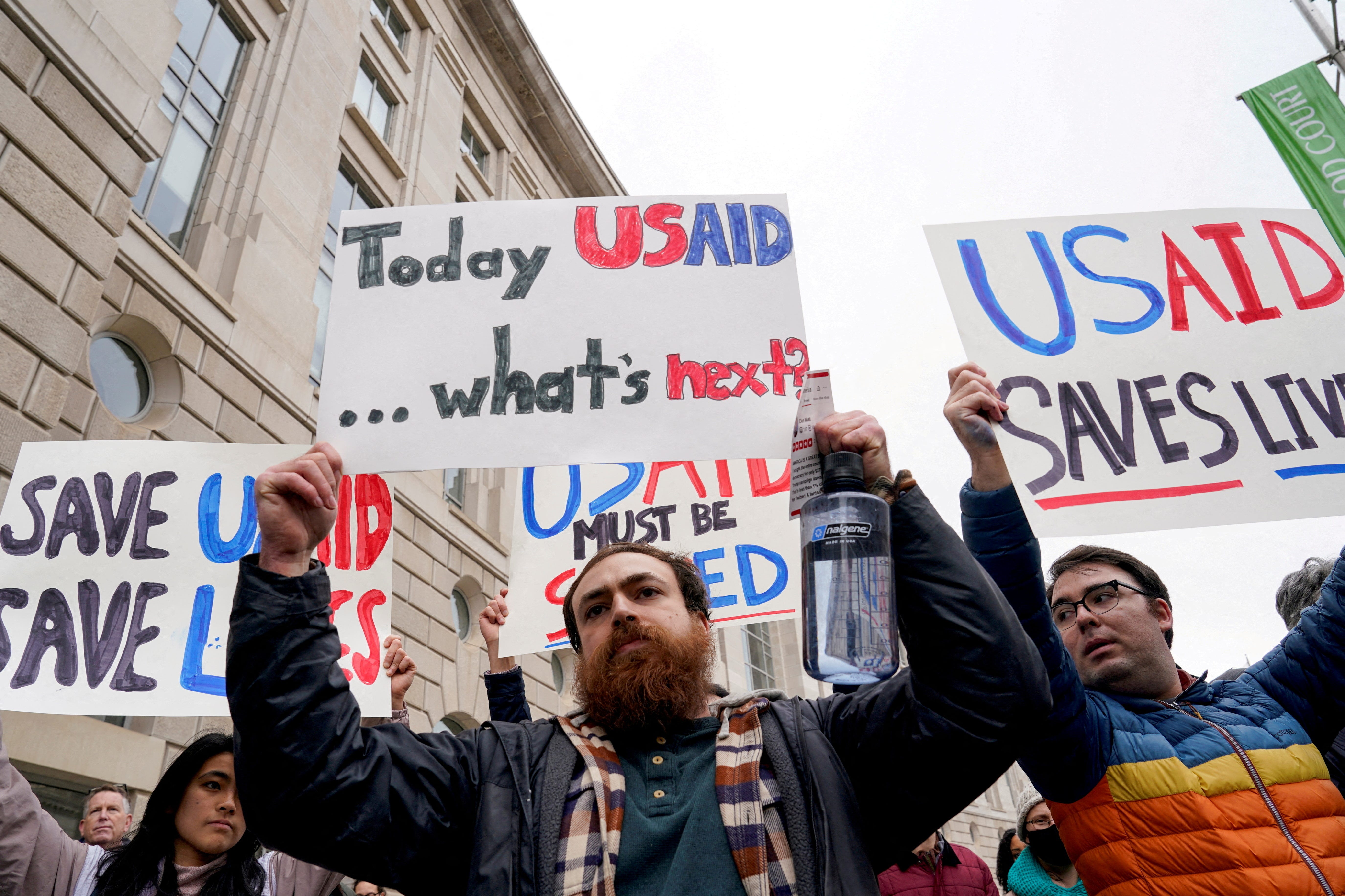 People hold placards outside the USAID building, after billionaire Elon Musk, who is heading President Donald Trump's drive to shrink the federal government, said work is underway to shut down the U.S. foreign aid agency USAID, in Washington, on Feb. 3, 2025.