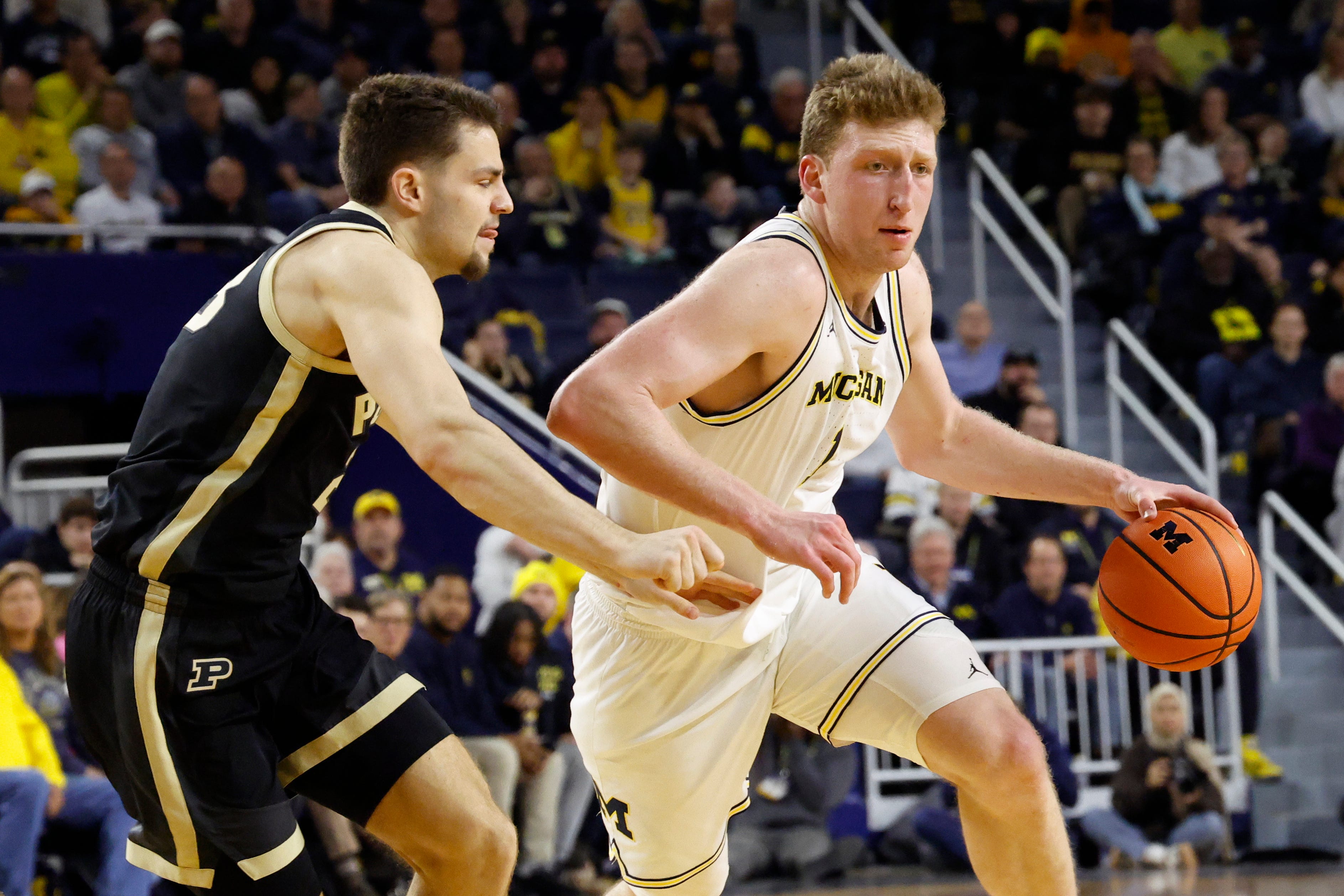 Michigan center Danny Wolf (1) dribbles against Purdue forward Camden Heide (23) in the first half at Crisler Center.
