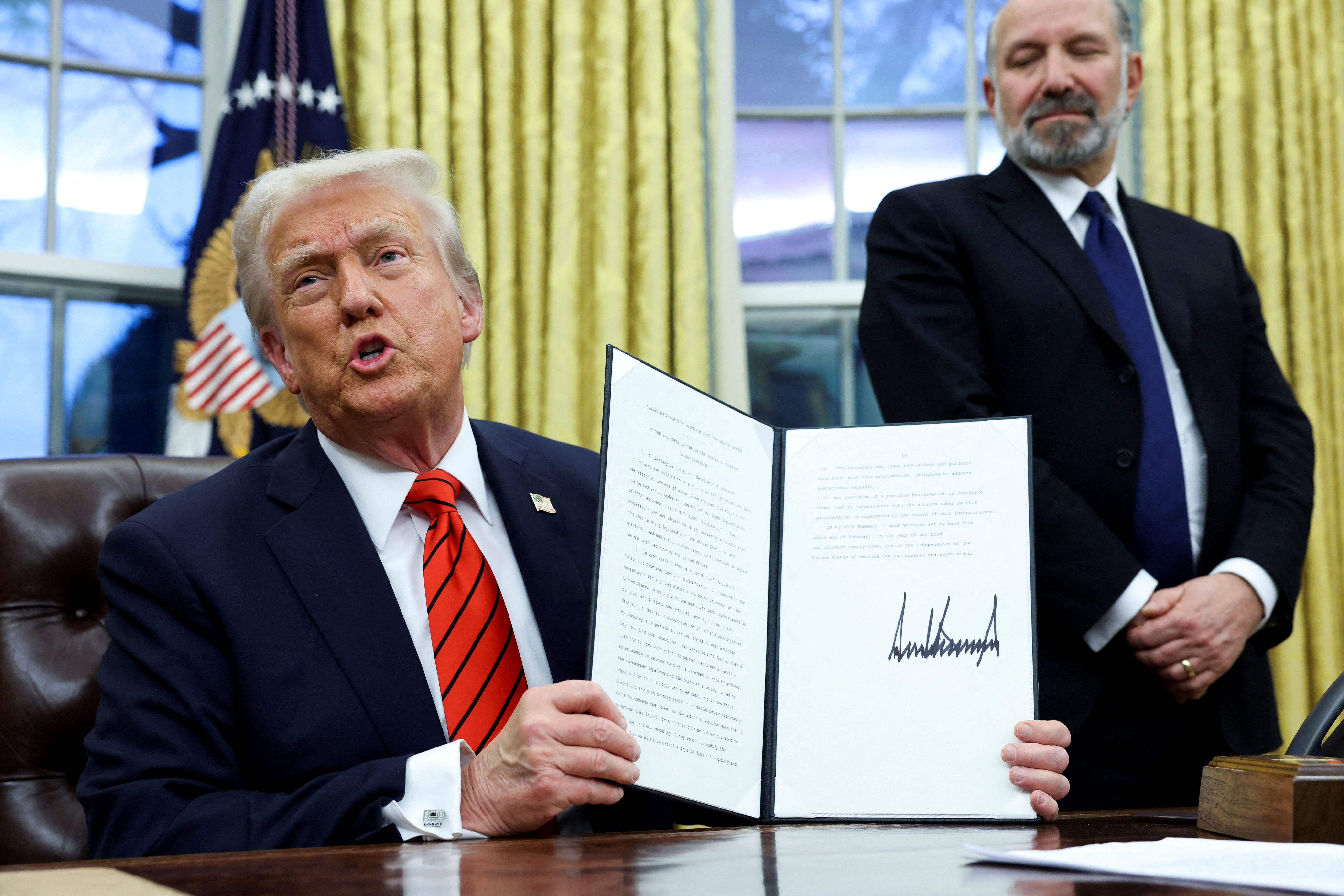 President Donald Trump holds a signed executive order on tariffs on aluminum imports in the Oval Office on Feb. 10, 2025.