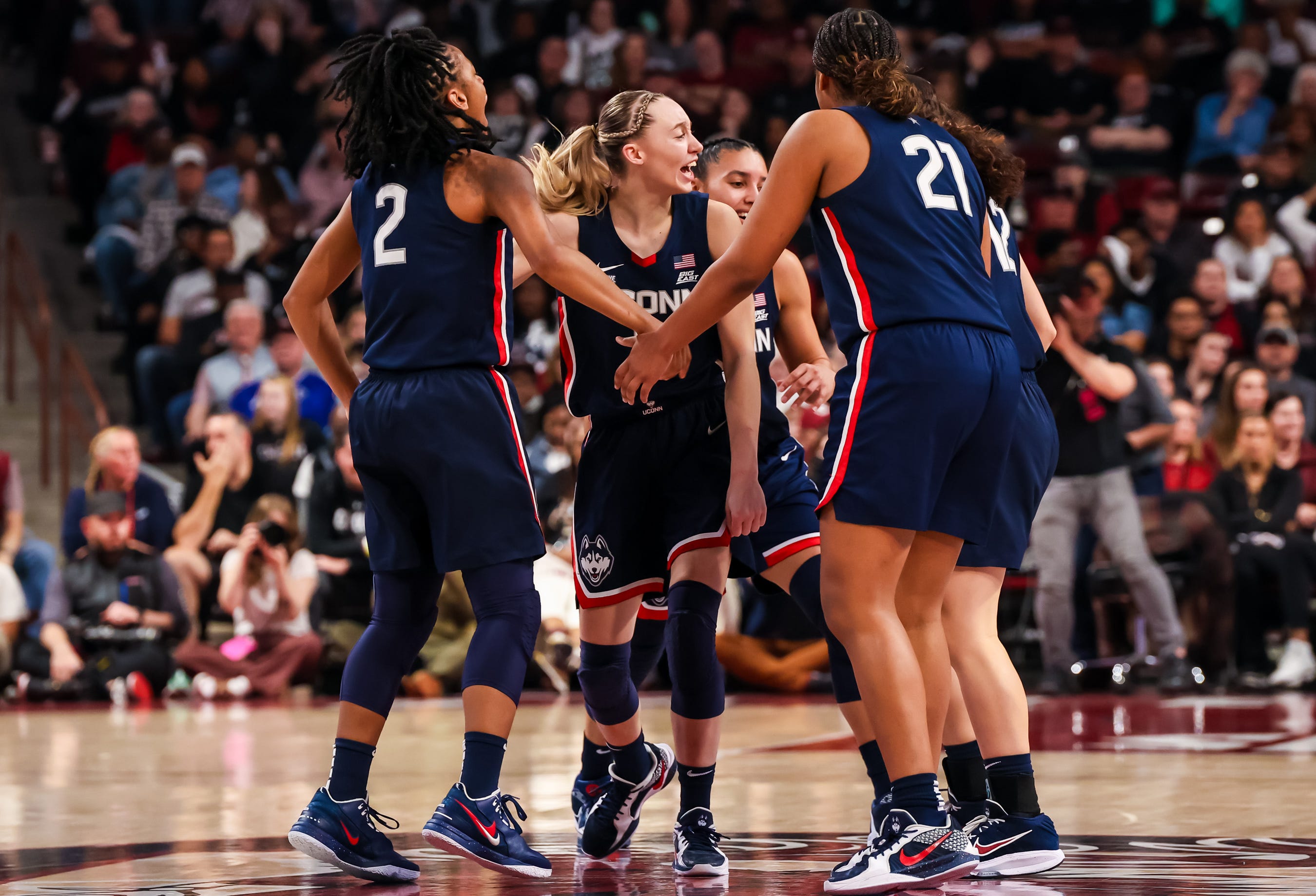 UConn Huskies guard KK Arnold (2), guard Paige Bueckers (5) and forward Sarah Strong (21) celebrate a three point basket against the South Carolina Gamecocks in the first half at Colonial Life Arena on Feb 16, 2025.