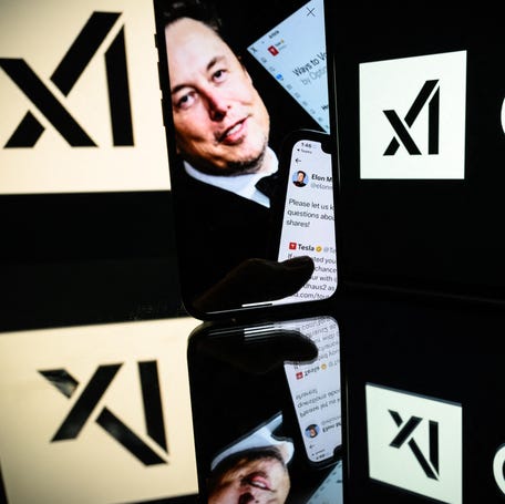Screens displaying the logo of Grok, a generative artificial intelligence chatbot developed by xAI, and Elon Musk. The billionaire tech mogul founded xAI as a challenger to Microsoft-backed OpenAI and Alphabet's Google.