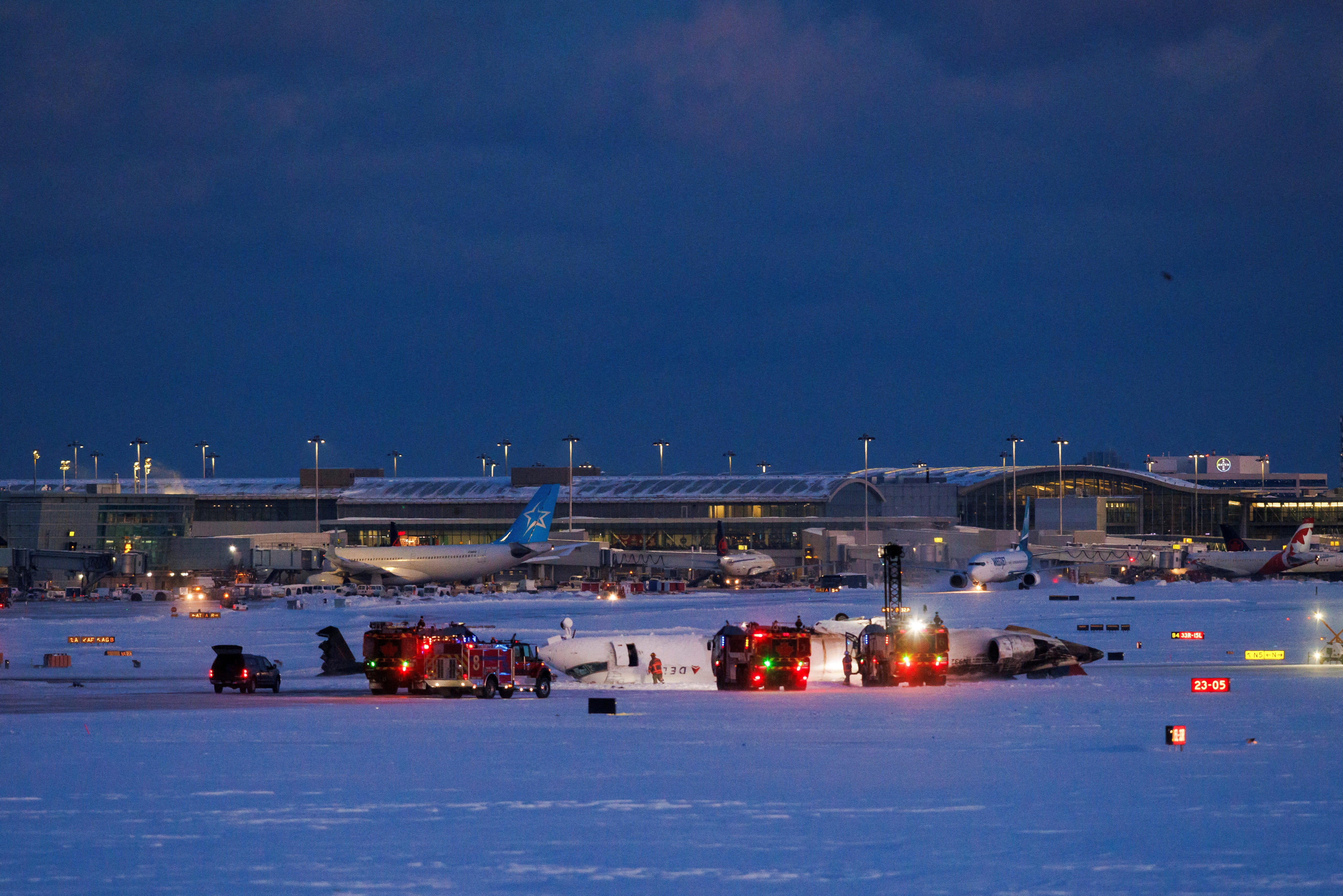 Emergency responders operate around a plane on a runway after a plane crash at Toronto Pearson International Airport in Mississauga, Ontario, Canada February 17, 2025. REUTERS/Cole Burston