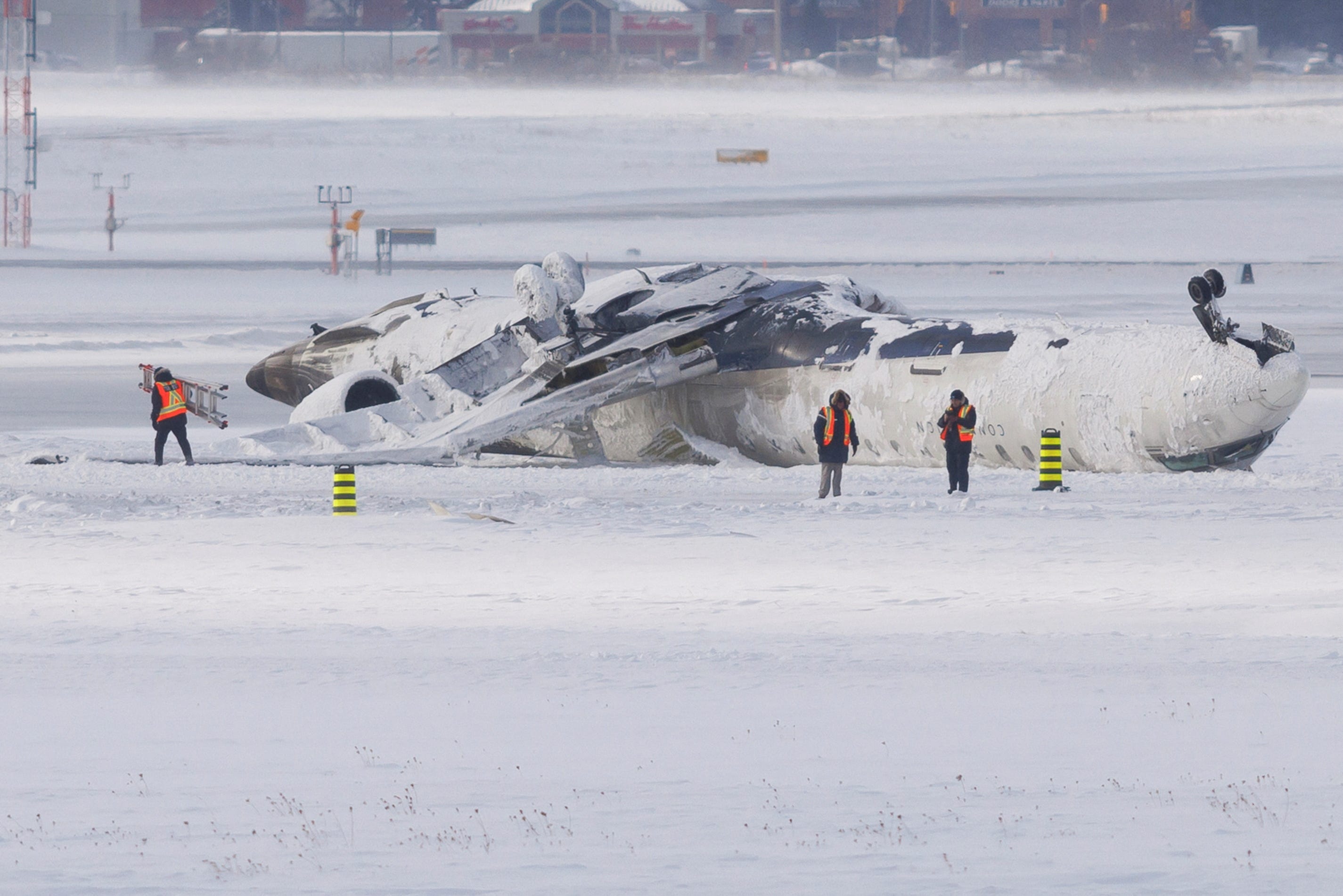 The wreckage of a Delta Air Lines operated CRJ900 aircraft lies on the runway following a crash at Toronto Pearson International Airport in Mississauga, Ontario, Canada February 18, 2025. REUTERS/Cole Burston
