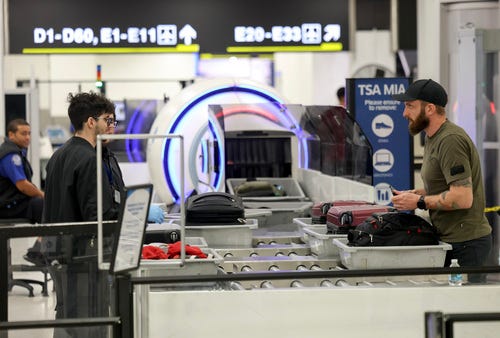 Travelers go through a TSA Pre checkpoint at the Miami International Airport as some of the year's busiest travel days occur during the holiday season on December 20, 2024 in Miami, Florida.