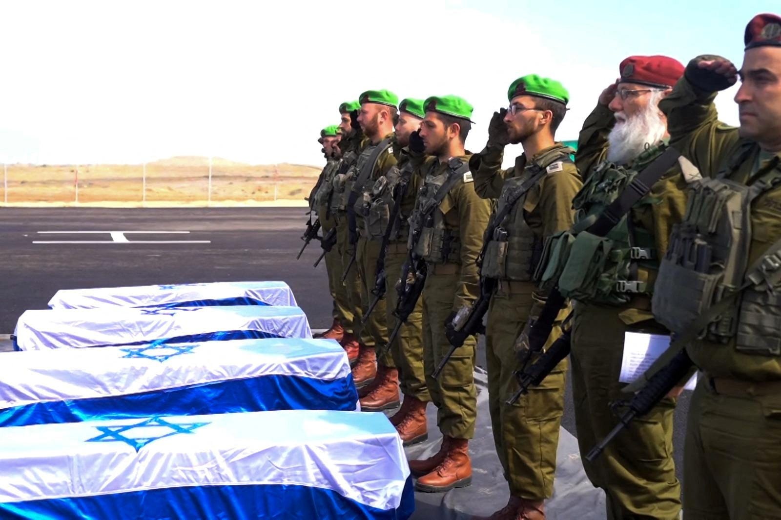 Israeli soldiers salute as they receive the coffins with the bodies of four deceased hostages who were kidnapped during the deadly October 7, 2023 attack by Hamas, and were handed over under the terms of a ceasefire between Hamas and Israel, in the Gaza Strip in this handout image obtained by Reuters on February 20, 2025. GPO/Handout via REUTERS THIS IMAGE HAS BEEN SUPPLIED BY A THIRD PARTY