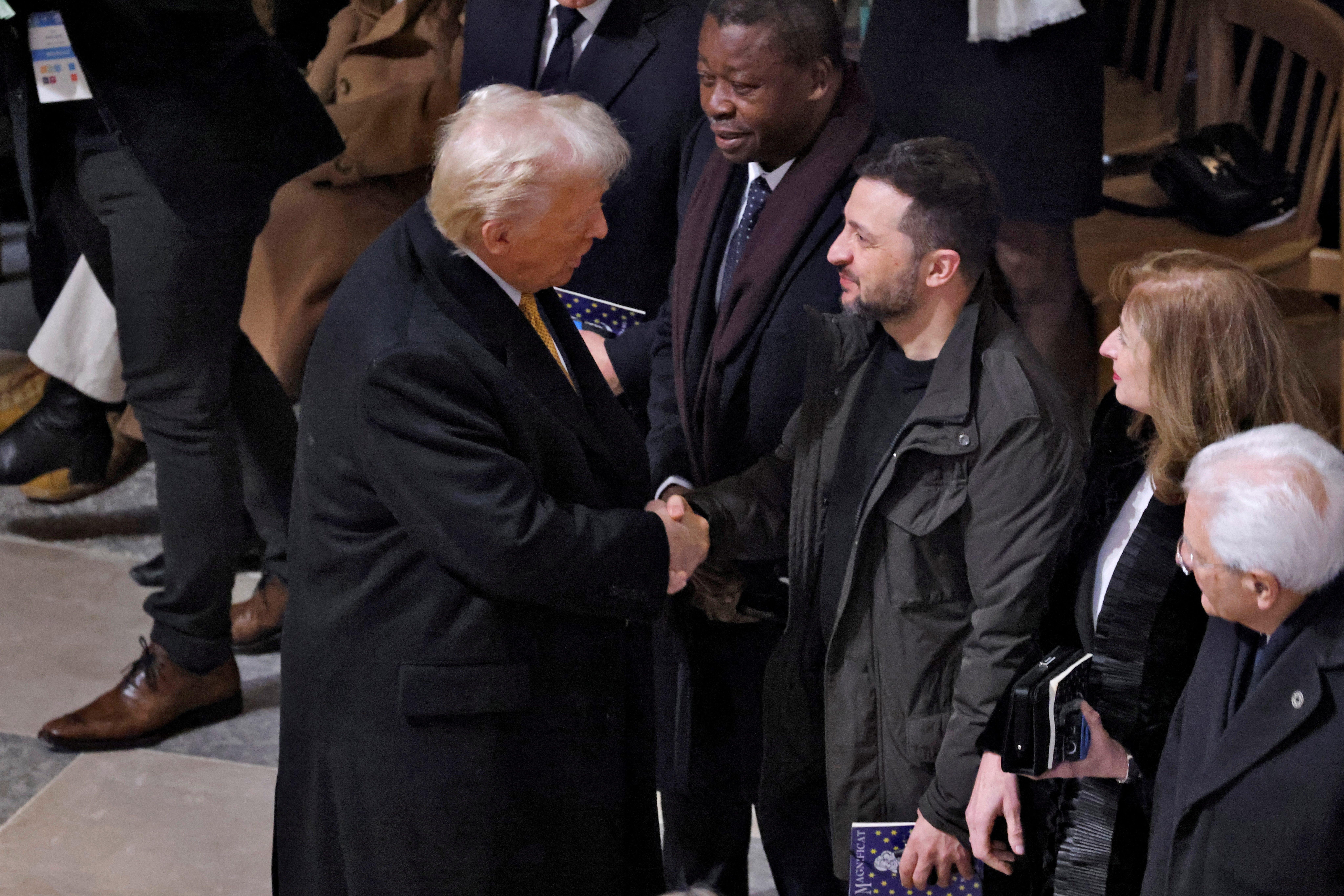 U.S. President-elect Donald Trump and Ukrainian President Volodymyr Zelenskiy shake hands inside the Notre-Dame de Paris Cathedral ahead of a ceremony to mark its re-opening following the 2019 fire, in Paris, France, December 7, 2024. LUDOVIC MARIN/Pool via REUTERS