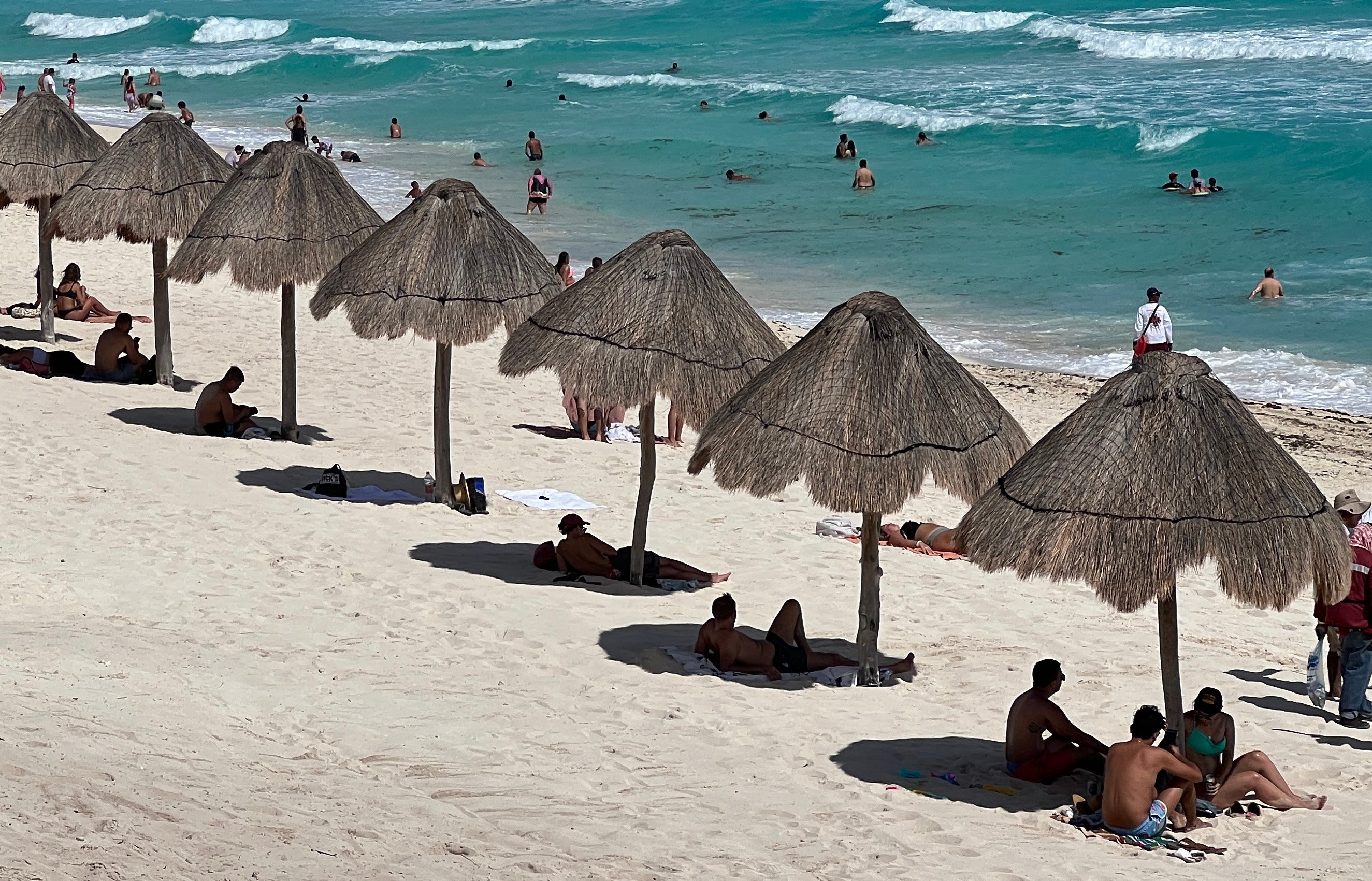 People enjoy a day at Playa Delfines beach (Dolphin Beach) at the Hotel Zone of Cancun, Quintana Roo State, Mexico, on November 8, 2022. (Photo by Daniel SLIM / AFP) (Photo by DANIEL SLIM/AFP via Getty Images)