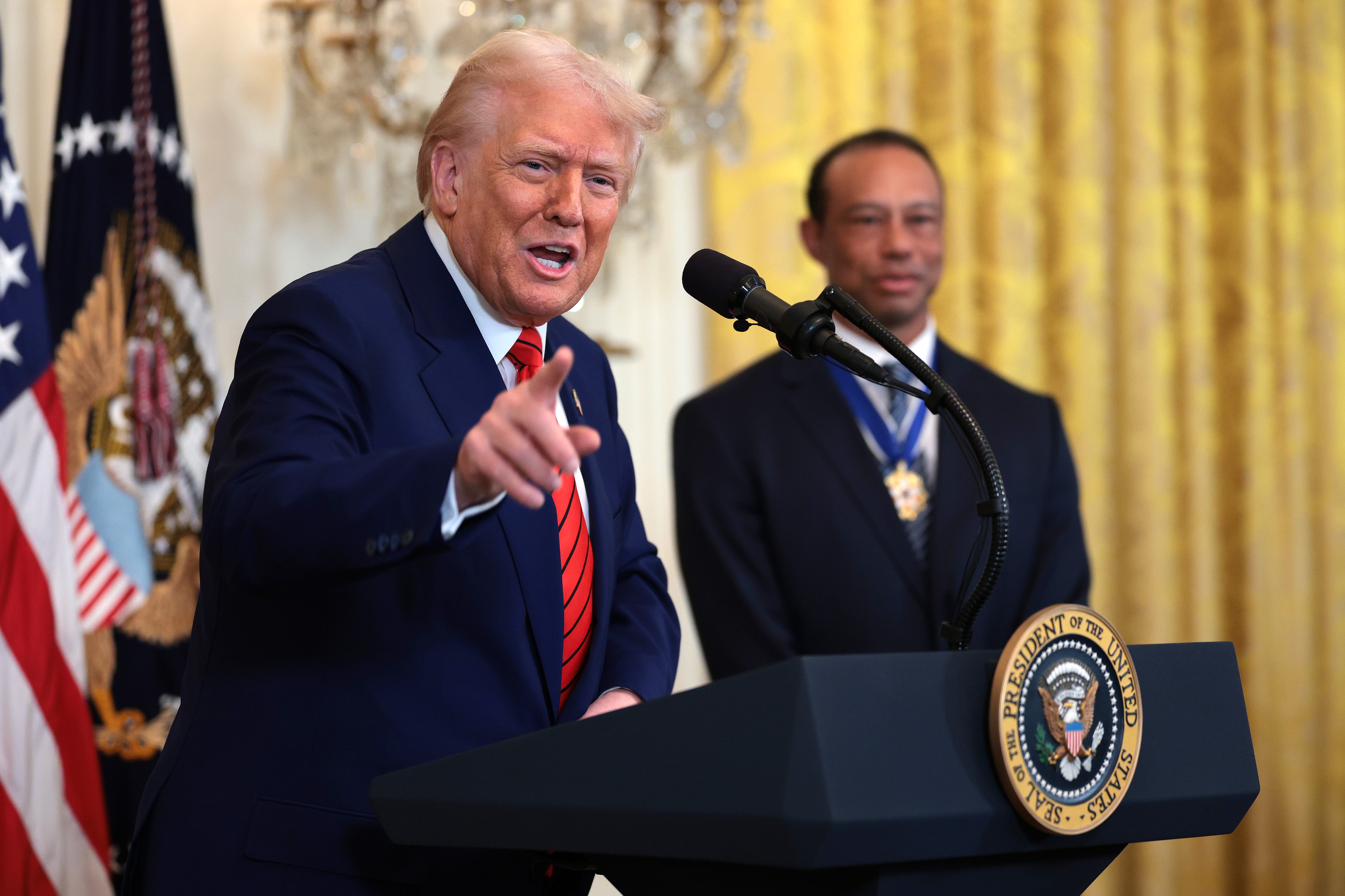 President Donald Trump, joined by golf legend Tiger Woods, speaks during a reception honoring Black History Month in the East Room of the White House on February 20. Trump has signed a series of executive orders ending federal DEI programs.