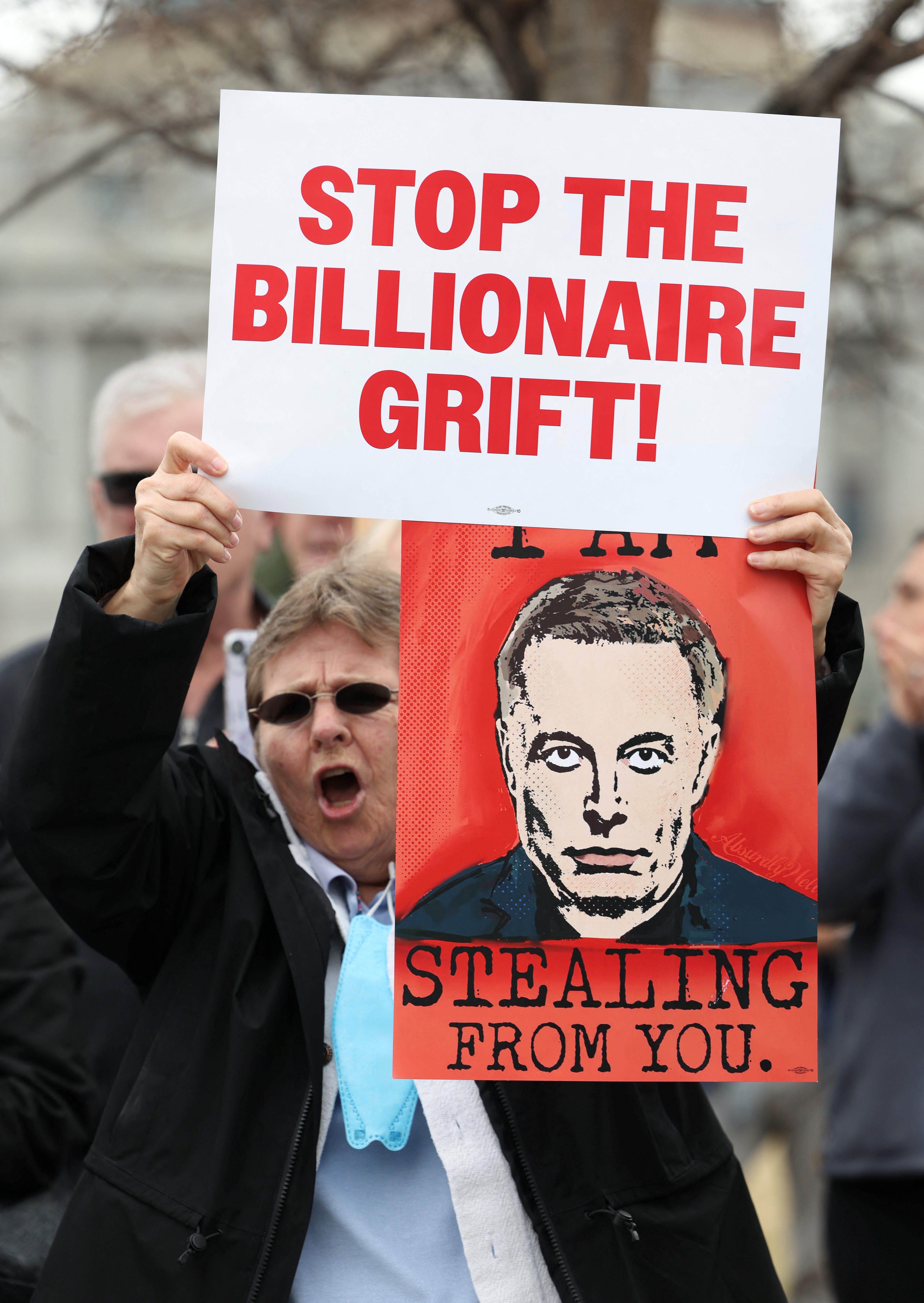 A demonstrator protests President Donald Trump and Elon Musk outside the U.S. Capitol on Feb. 25, 2025.