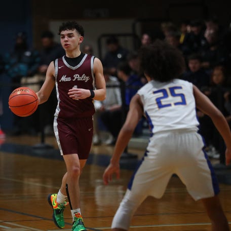 New Paltz's Cayden Dones brings the ball into play as Ellenville's Maxwell Kinscy covers him during the MHAL boys basketball championship game on February 26, 2025.