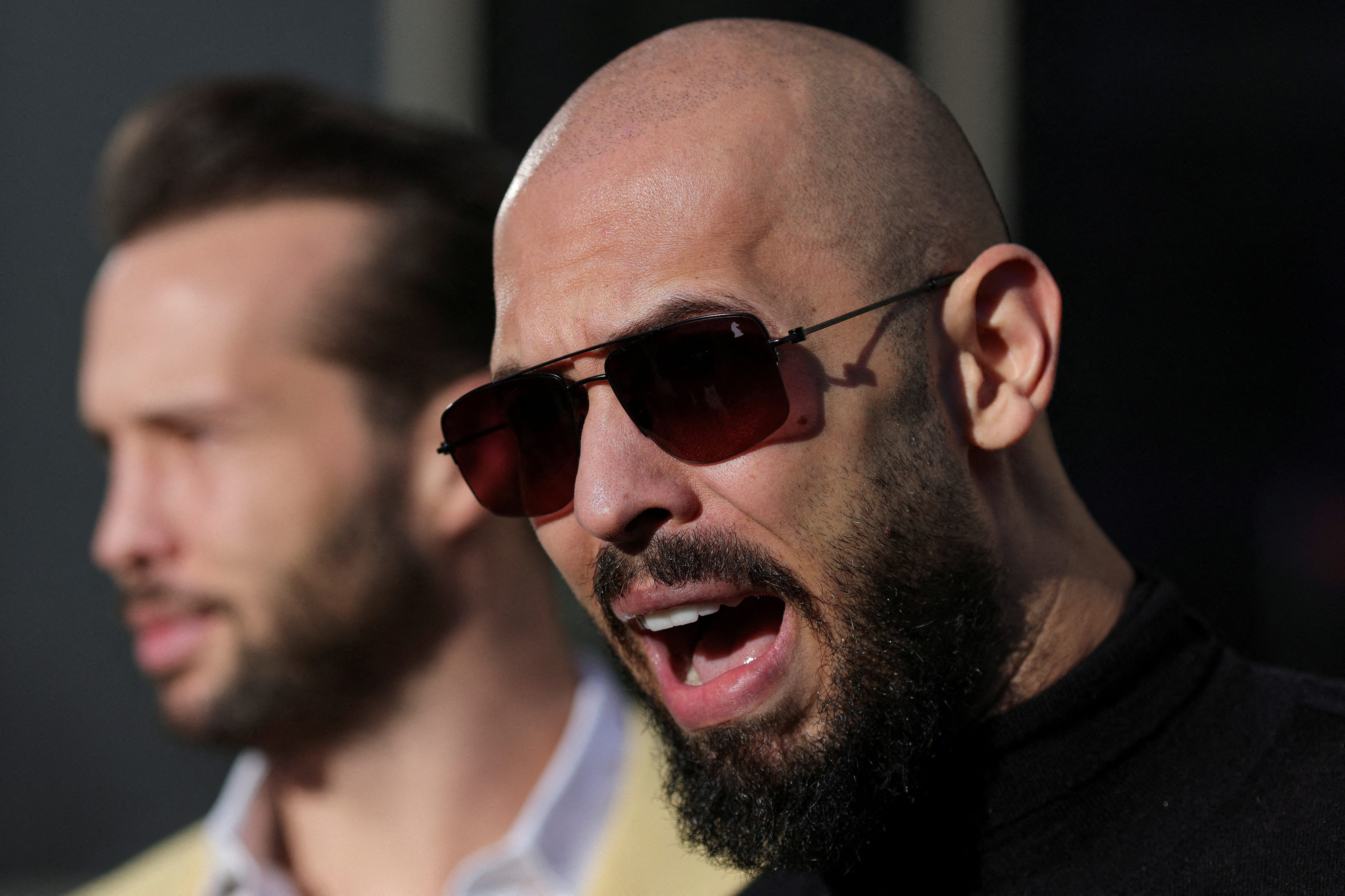 Andrew Tate, next to his brother Tristan Tate, talks to media representatives after exiting the Bucharest courthouse, in Bucharest, Romania, January 9, 2025.