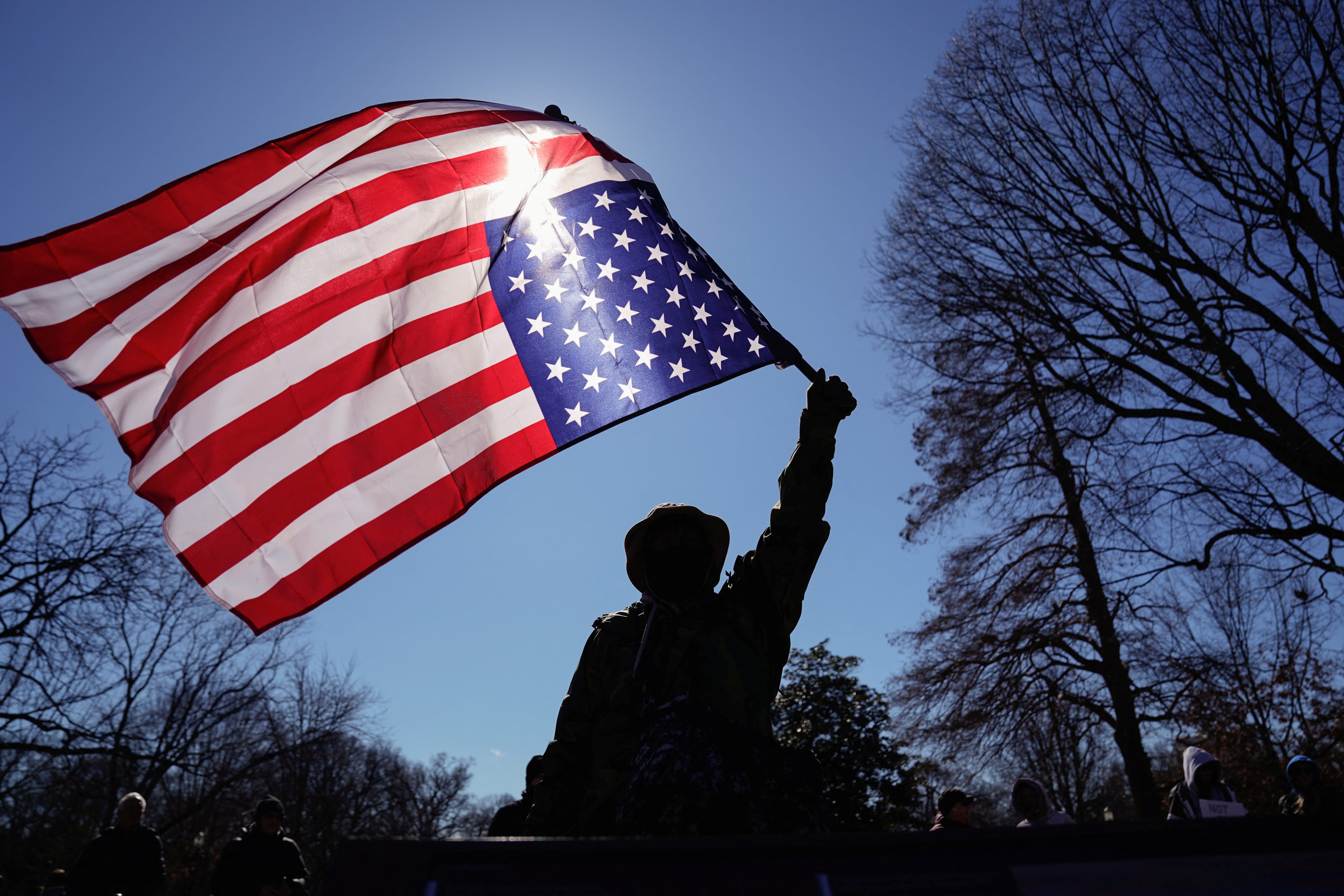 A person holds a U.S. flag upside-down during a protest outside the White House on President's Day in Washington, D.C., U.S., February 17, 2025. REUTERS/Kent Nishimura
