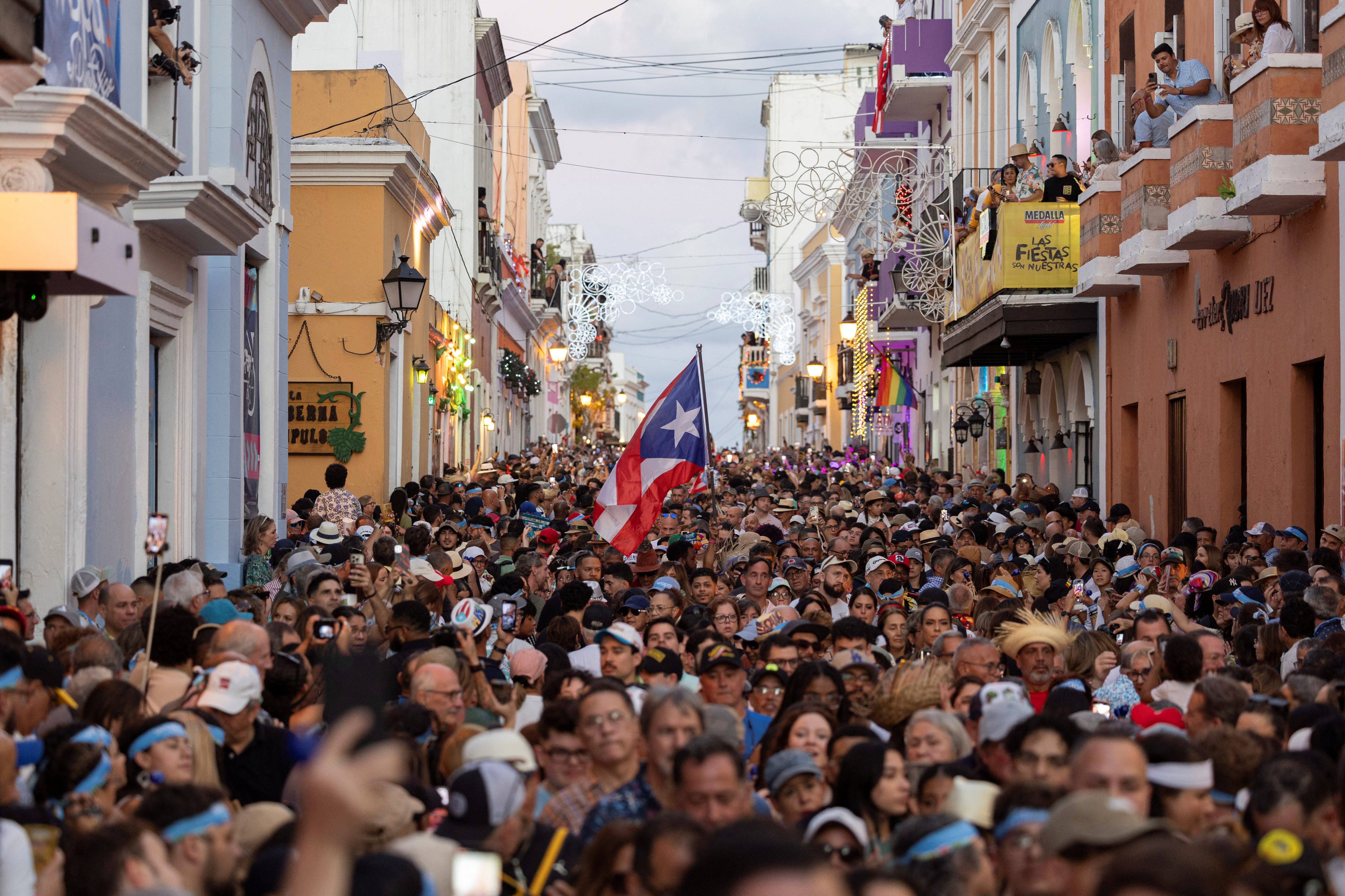 A Puerto Rican flag waves among thousands of people attending the inauguration day of the 55th edition of the annual San Sebastian Street Festival in Old San Juan, Puerto Rico, Jan. 16, 2025.