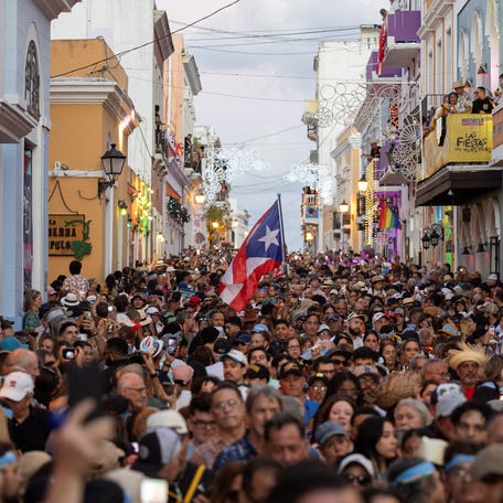 A Puerto Rican flag waves among thousands of people attending the inauguration day of the 55th edition of the annual San Sebastian Street Festival in Old San Juan, Puerto Rico, Jan. 16, 2025.