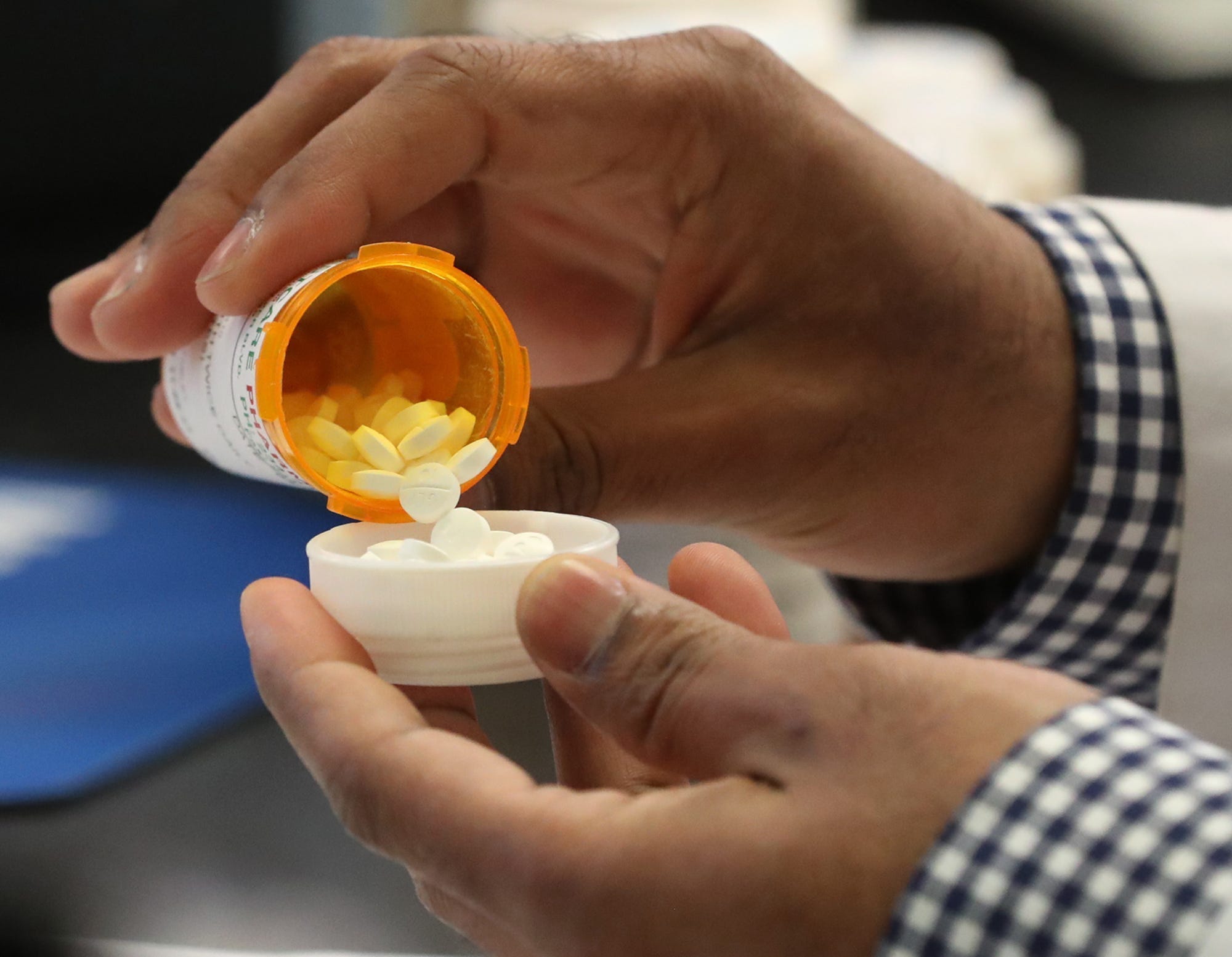 Ganga Kalikotay, a pharmacist at BestCare Pharmacy visually verifies medicine against the computer image of the pill markings as he checks a prescription in Akron on Monday.