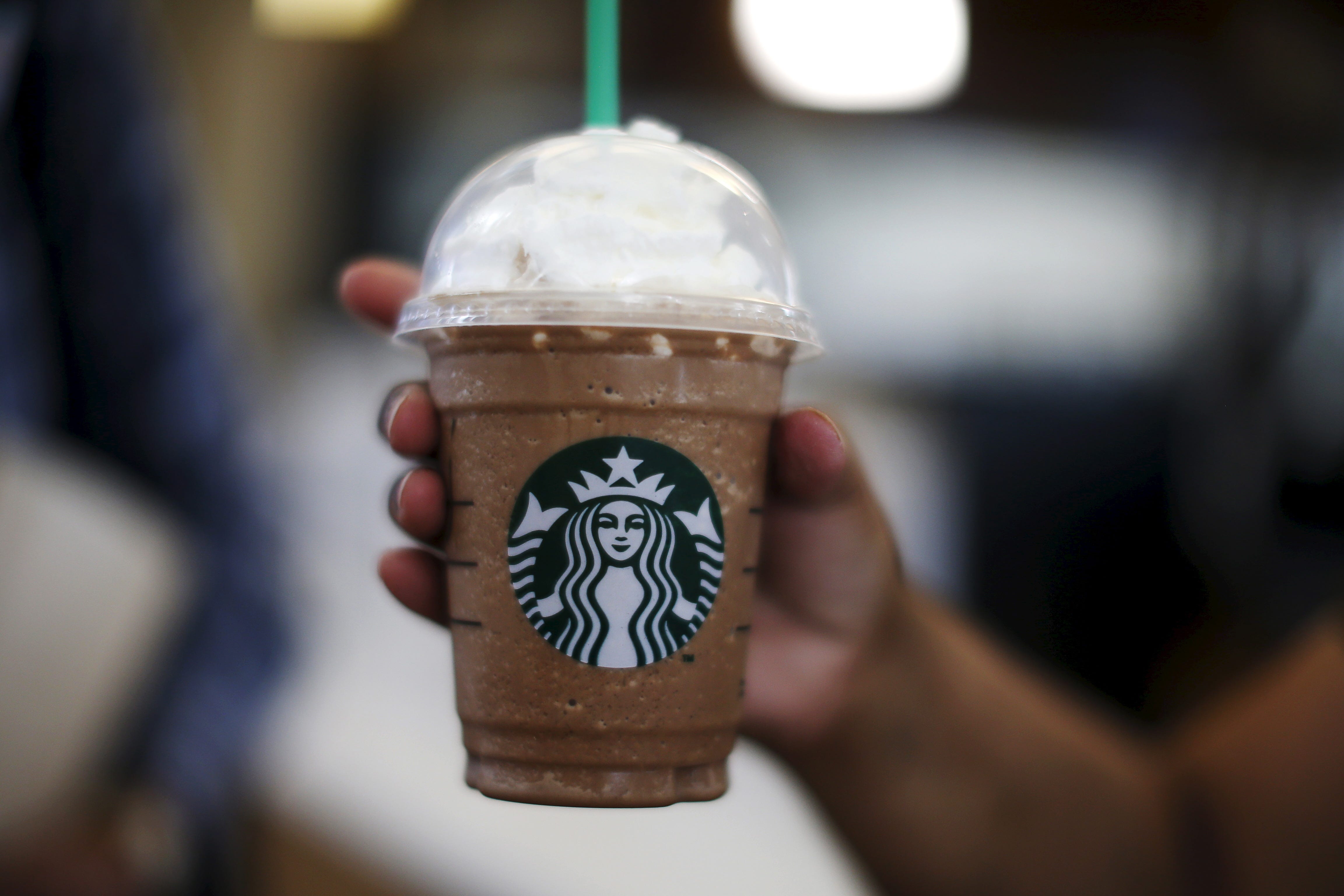 A woman holds a Frappuccino at a Starbucks coffeehouse inside the Tom Bradley terminal at LAX airport in Los Angeles on Oct. 27, 2015.
