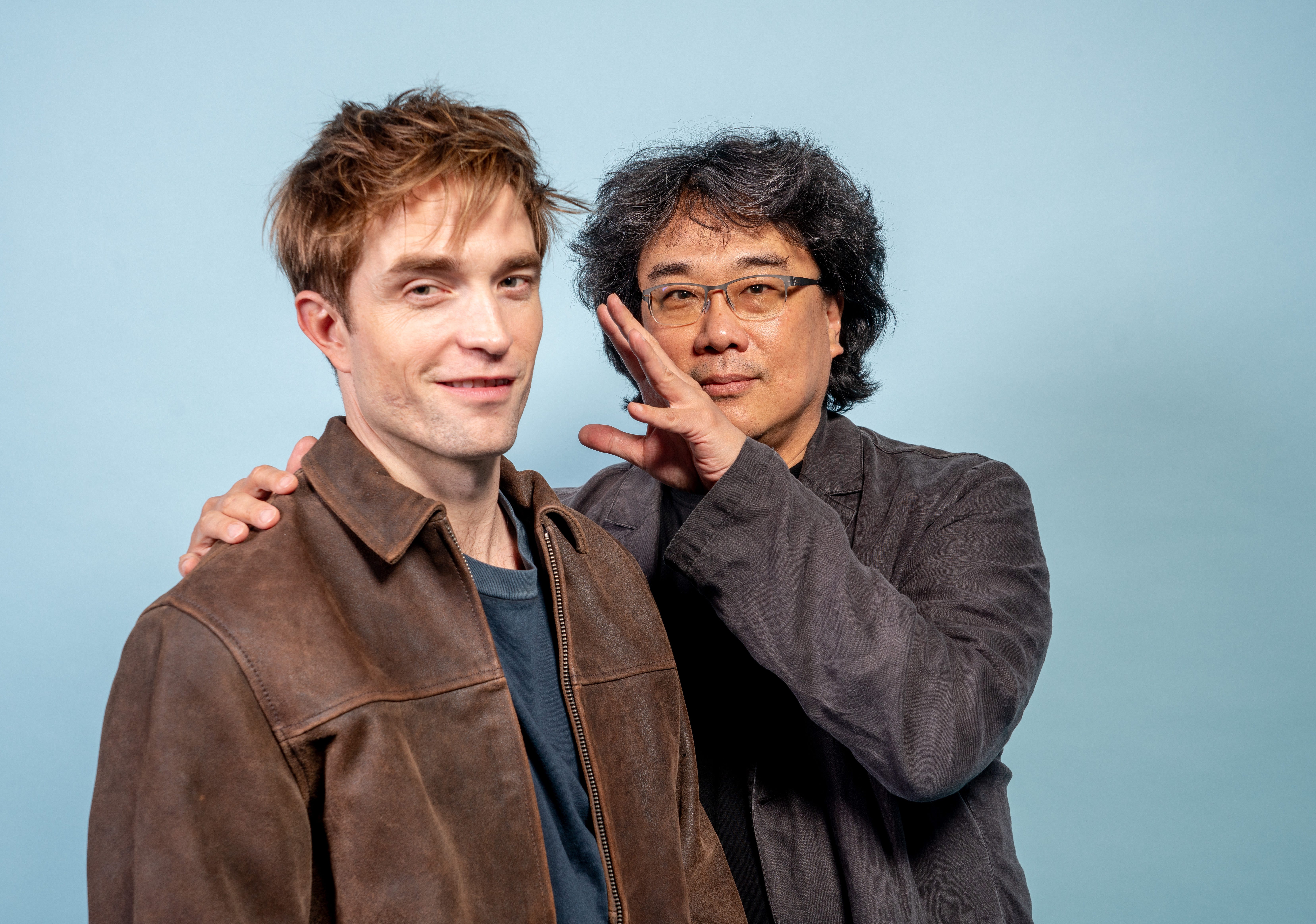 Robert Pattinson (left) poses with director Bong Joon Ho (left) during a photo shoot for their new movie "Mickey 17."