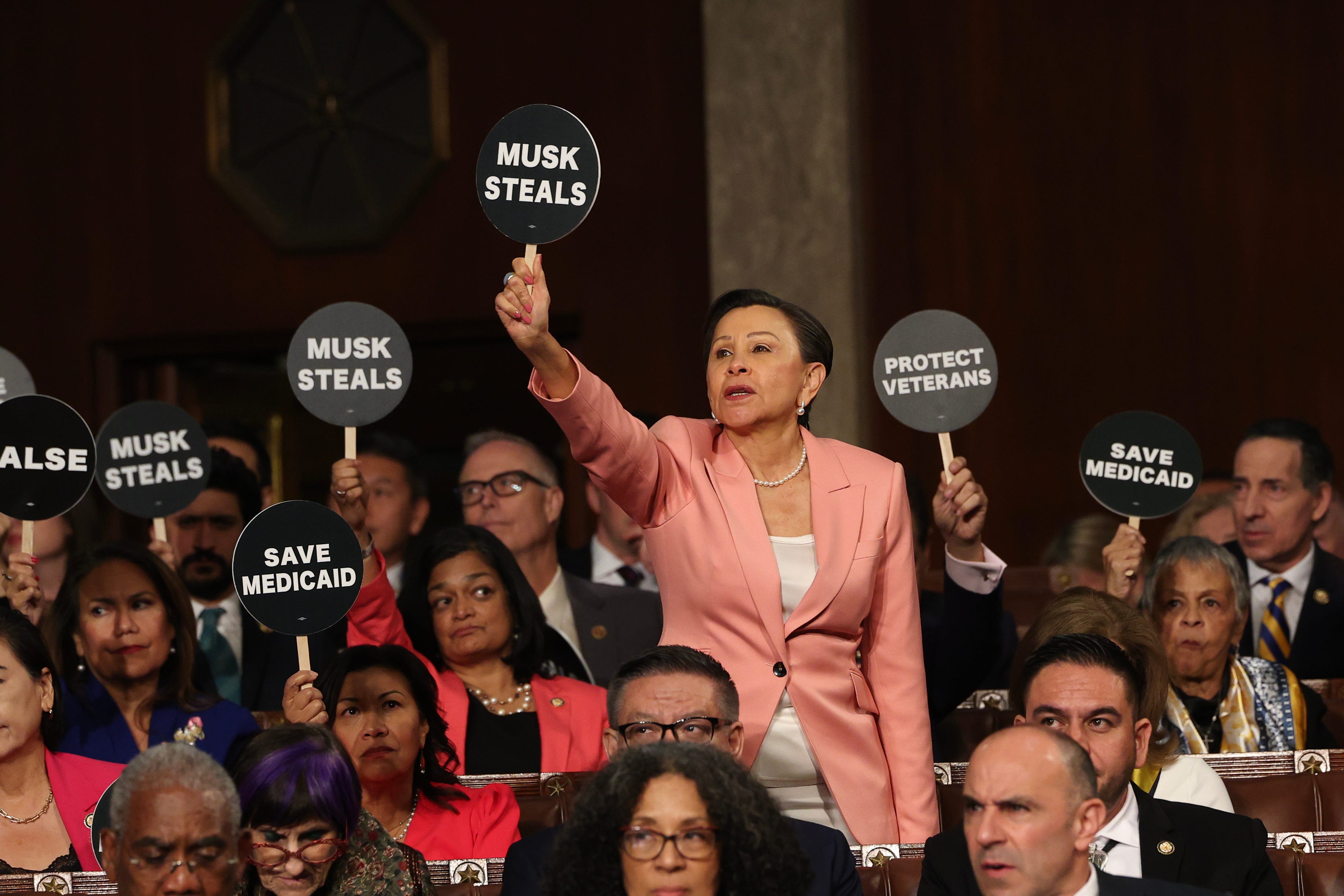 Rep. Nydia Velázquez, D-N.Y., holds a protest sign with fellow Democratic congressional members as President Donald Trump addresses a joint session of Congress at the U.S. Capitol on March 4, 2025.