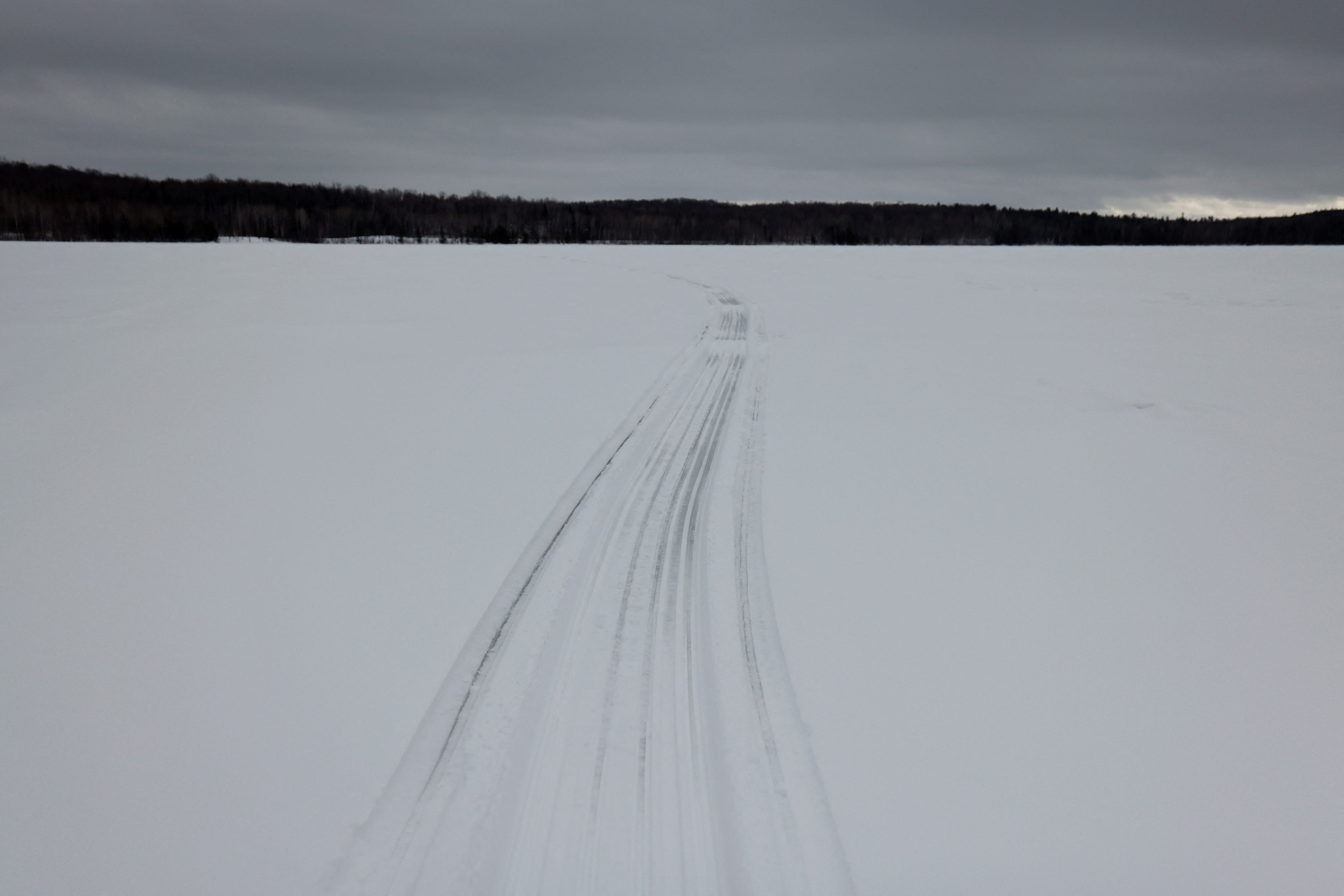Snowmobile tracks are pictured on a lake in the Kitigan Zibi Anishinabeg Reserve, Quebec, Canada, February 8, 2023. First Nations ice fishermen risk going out on ice as climate change affects the quality of the ice.