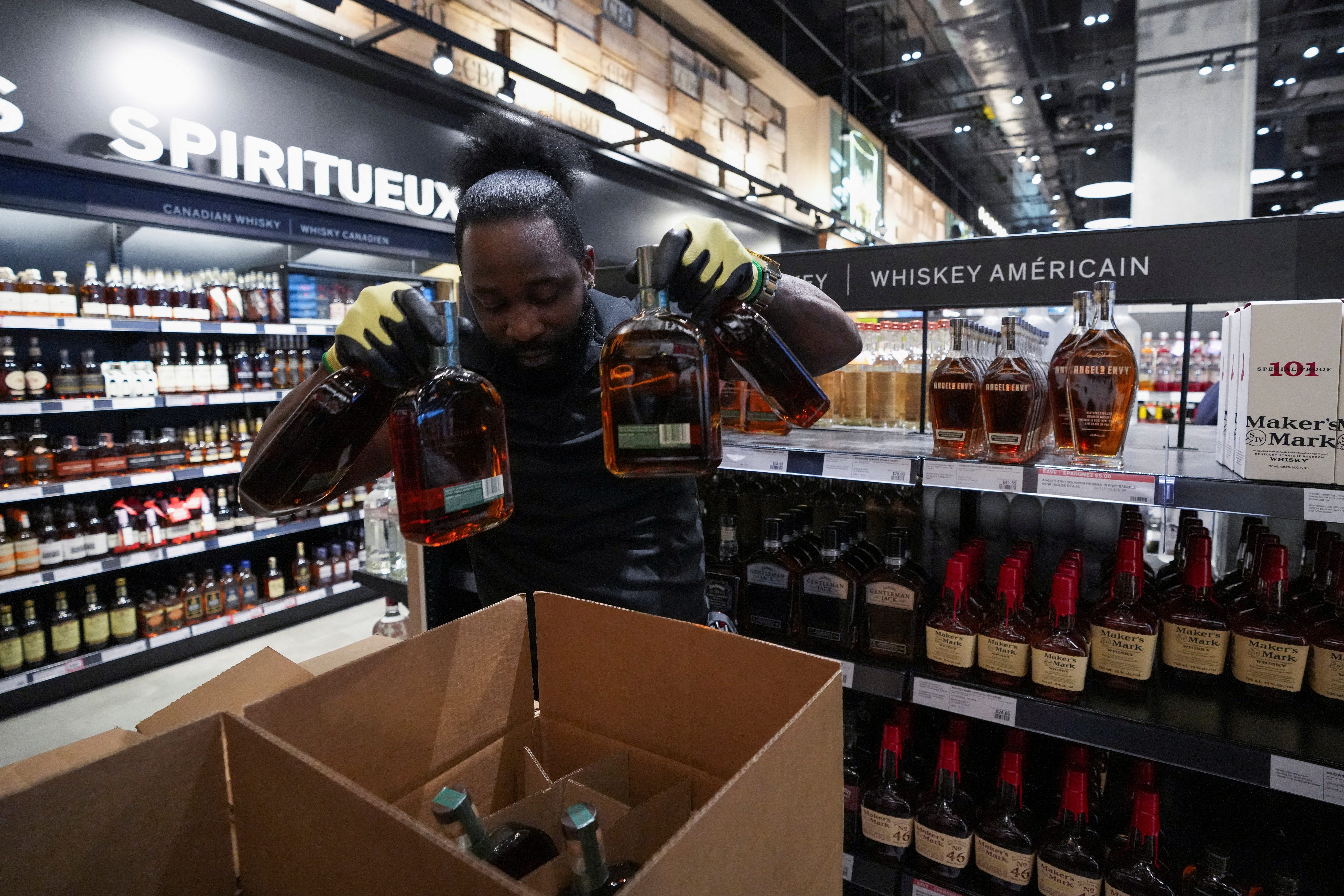 Staff member removes bottles of U.S. alcohol from the shelves of a Liquor Control Board of Ontario (LCBO) store, as part of retaliatory moves against tariffs announced by U.S. President Donald Trump, in Toronto, Ontario, Canada March 4, 2025.