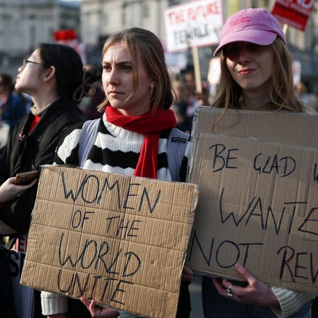 People holds placards during the Million Women Rise march, on the International Women's Day, at Trafalgar Square in London, Britain, March 8, 2025.