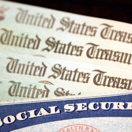 In this photo illustration, a Social Security card sits alongside checks from the U.S. Treasury on October 14, 2021 in Washington, DC.