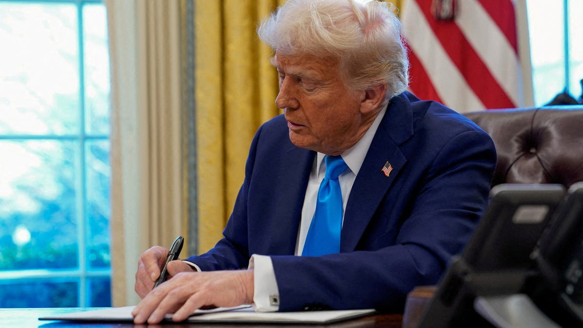 President Donald Trump signs a document in the Oval Office at the White House in Washington, on Feb. 4, 2025.