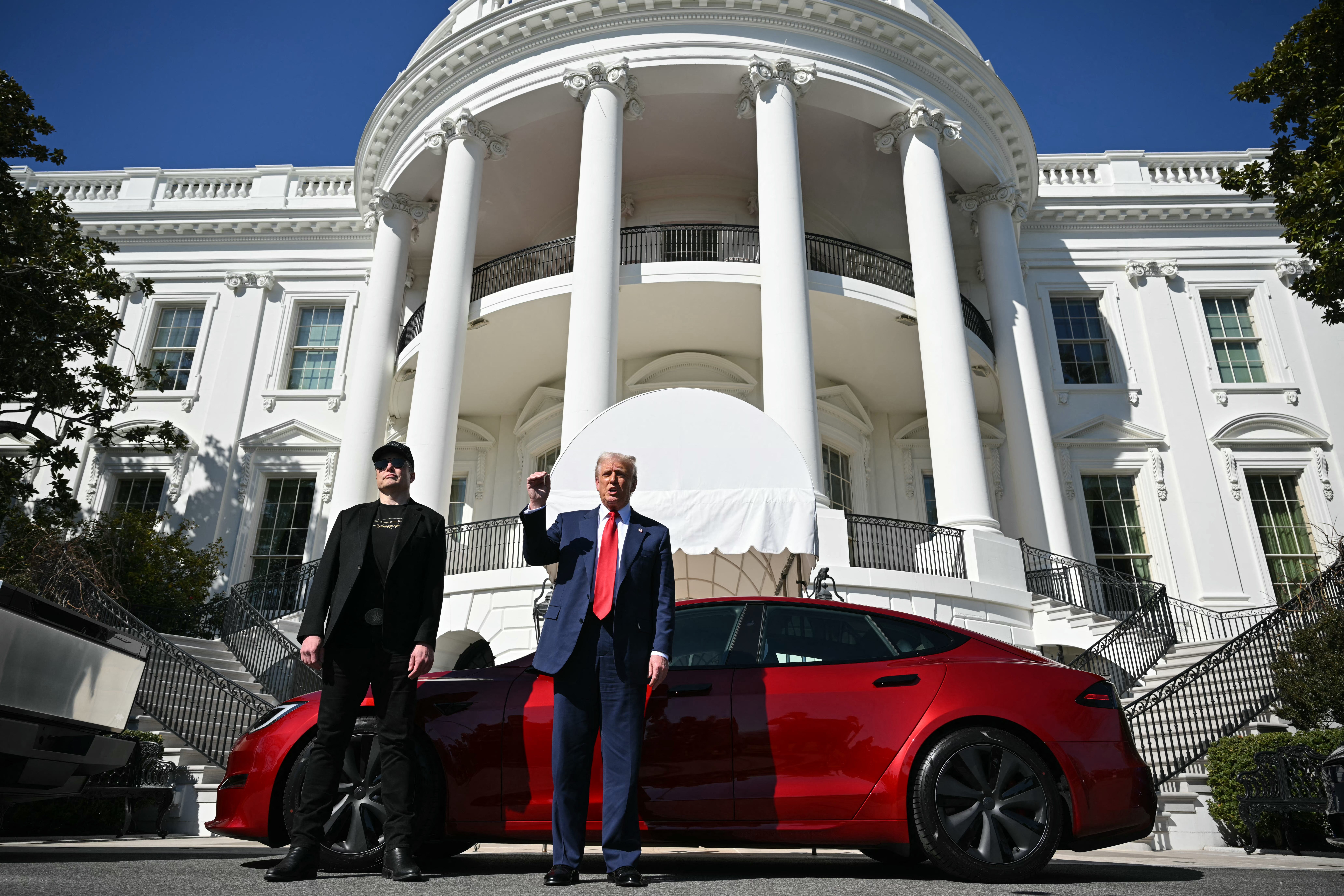 US President Donald Trump and Tesla CEO Elon Musk speak to the press as they stand next to a Tesla vehicle on the South Portico of the White House on March 11, 2025 in Washington, DC.
