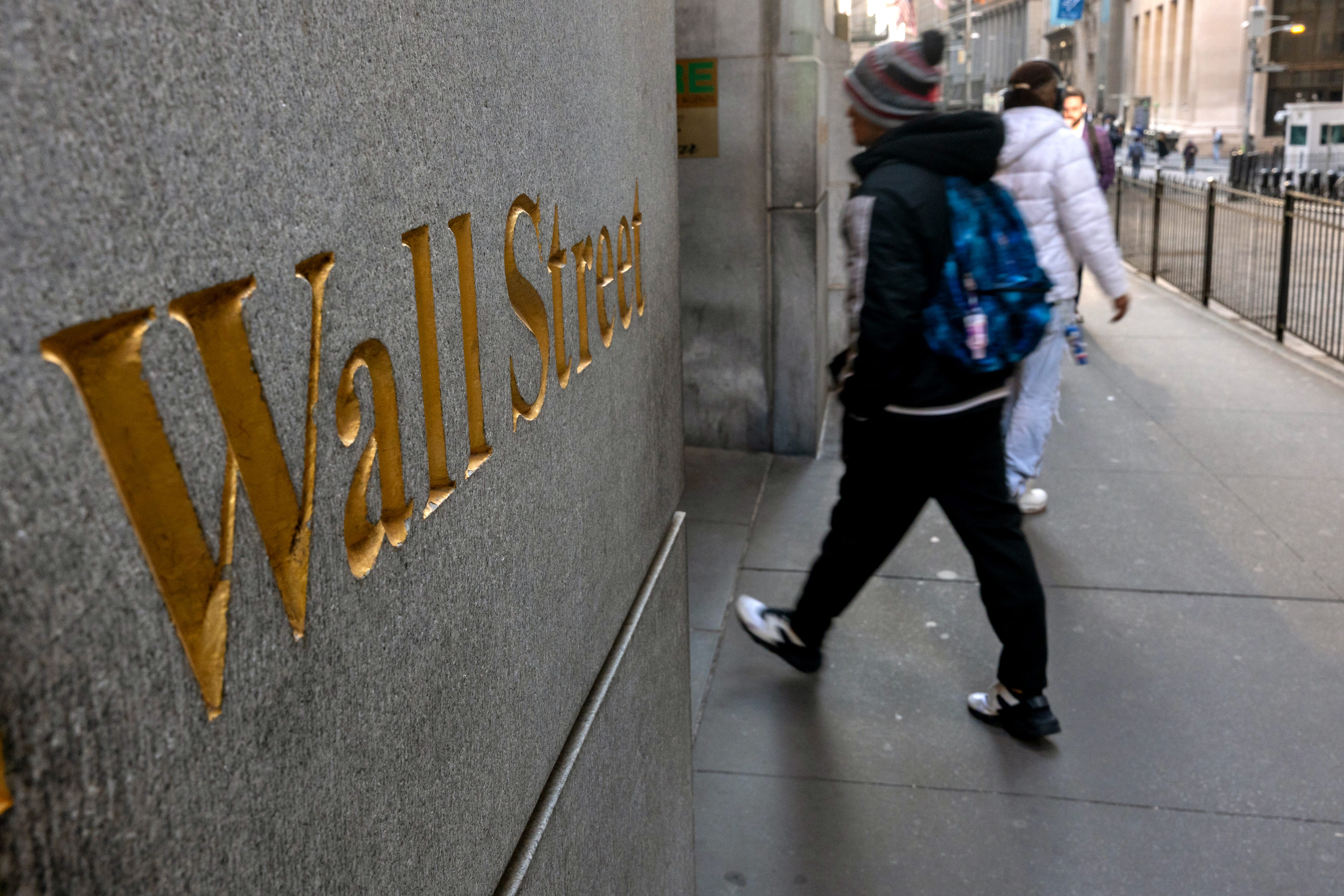 People walk along Wall Street by the New York Stock Exchange (NYSE) on March 11, 2025 in New York City. Following the worst day for the markets this year, the Dow was down nearly 500 points in morning trading.