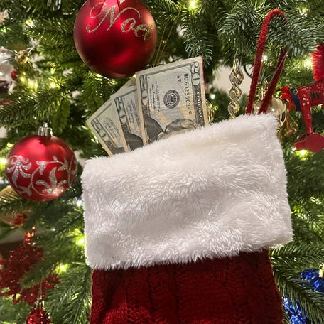 A stocking with 20 dollar bills hangs on a Christmas tree in this photo illustration taken on December 16, 2024.